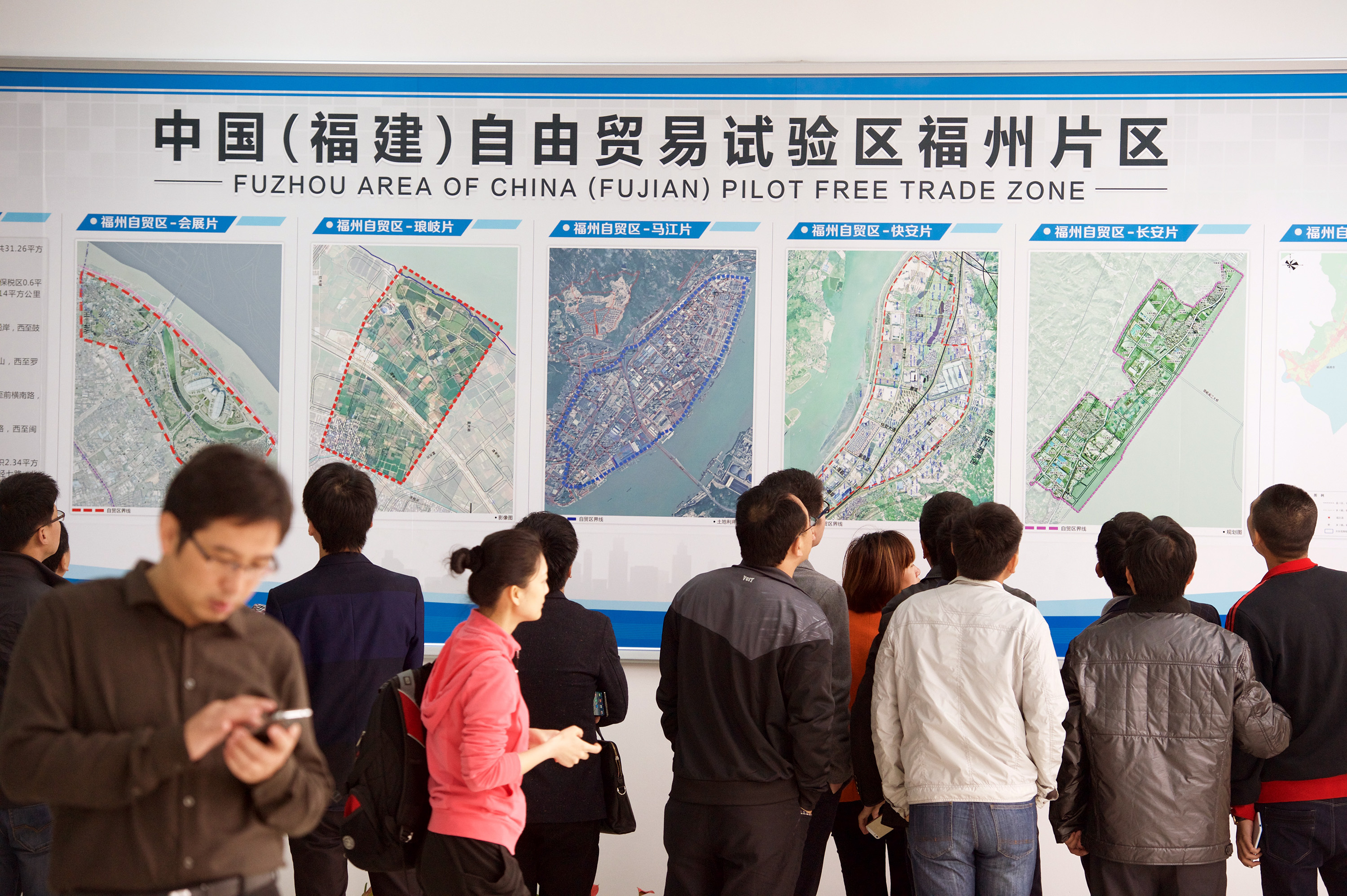 Business people in Fuzhou examine maps of the new free trade zone in Fujian province. Photo: Xinhua