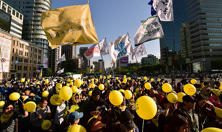 South Korean protestors march demanding for a fully independent inquiry into last year's Sewol ferry disaster in downtown Seoul on Saturday. Photo: AFP 