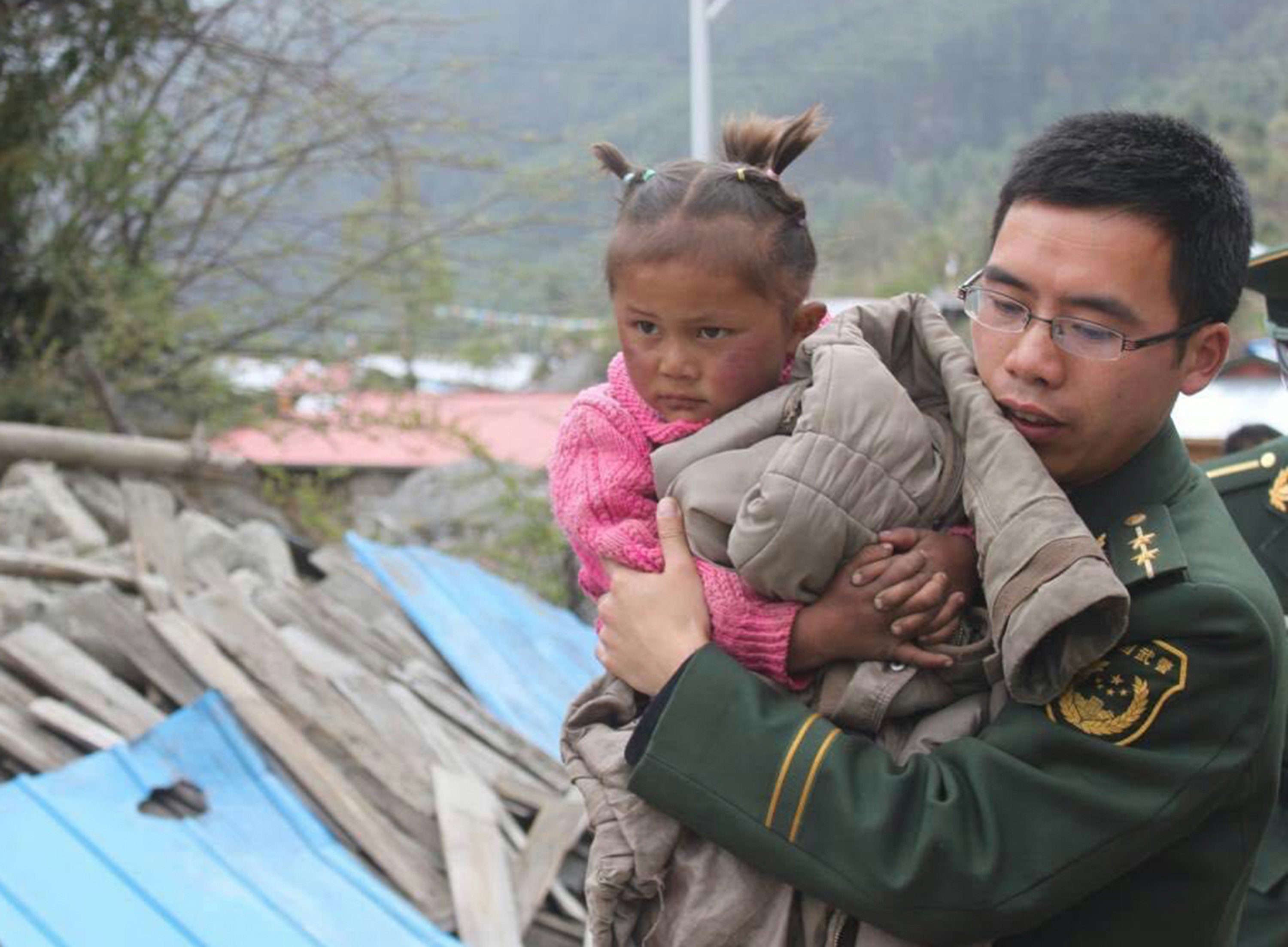 A soldier helps a child evacuate in Gyirong county in Xigaze, Tibet, on the weekend. Photo: TNs