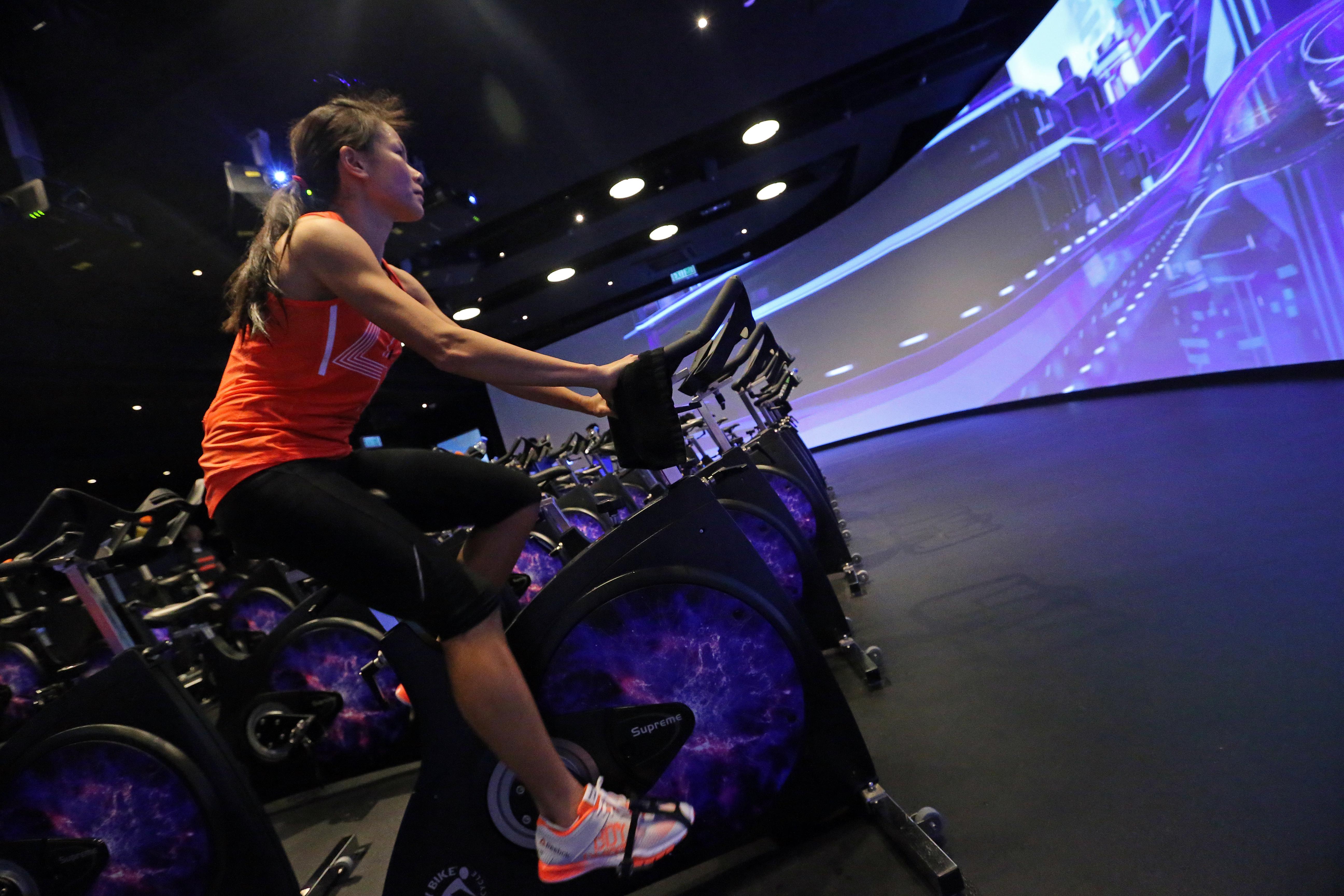 Jeanette Wang takes a roller coaster ride at Pure's immersive Fitness studio. Photo: David Wong