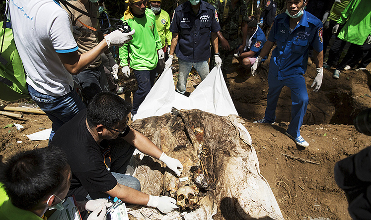 Human remains are retrieved from a mass grave at an abandoned people smuggling camp in Thailand's southern Songkhla province. Photo: Reuters