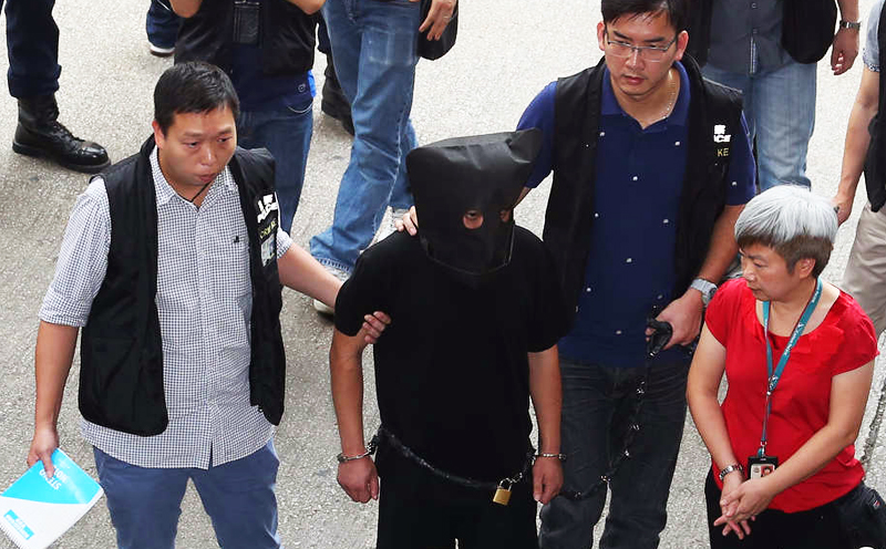 The suspect is escorted around vicinity of the MTR station and a nearby market during a reconstruction yesterday.