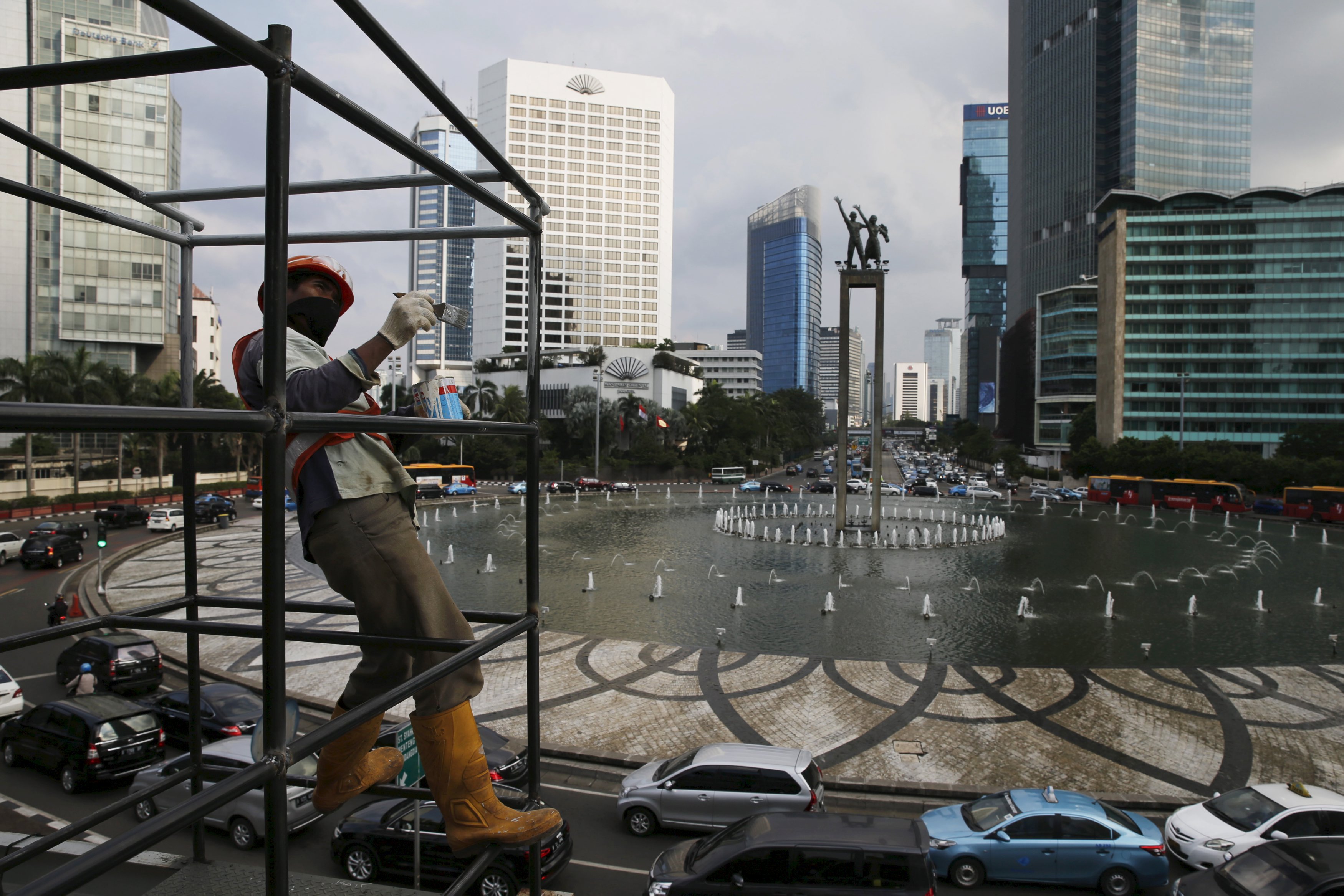 A worker paints a scaffolding for a transit station in Indonesia, the most populous country in Southeast Asia where an expanding middle class could shift global demand in the years ahead. Photo: Reuters