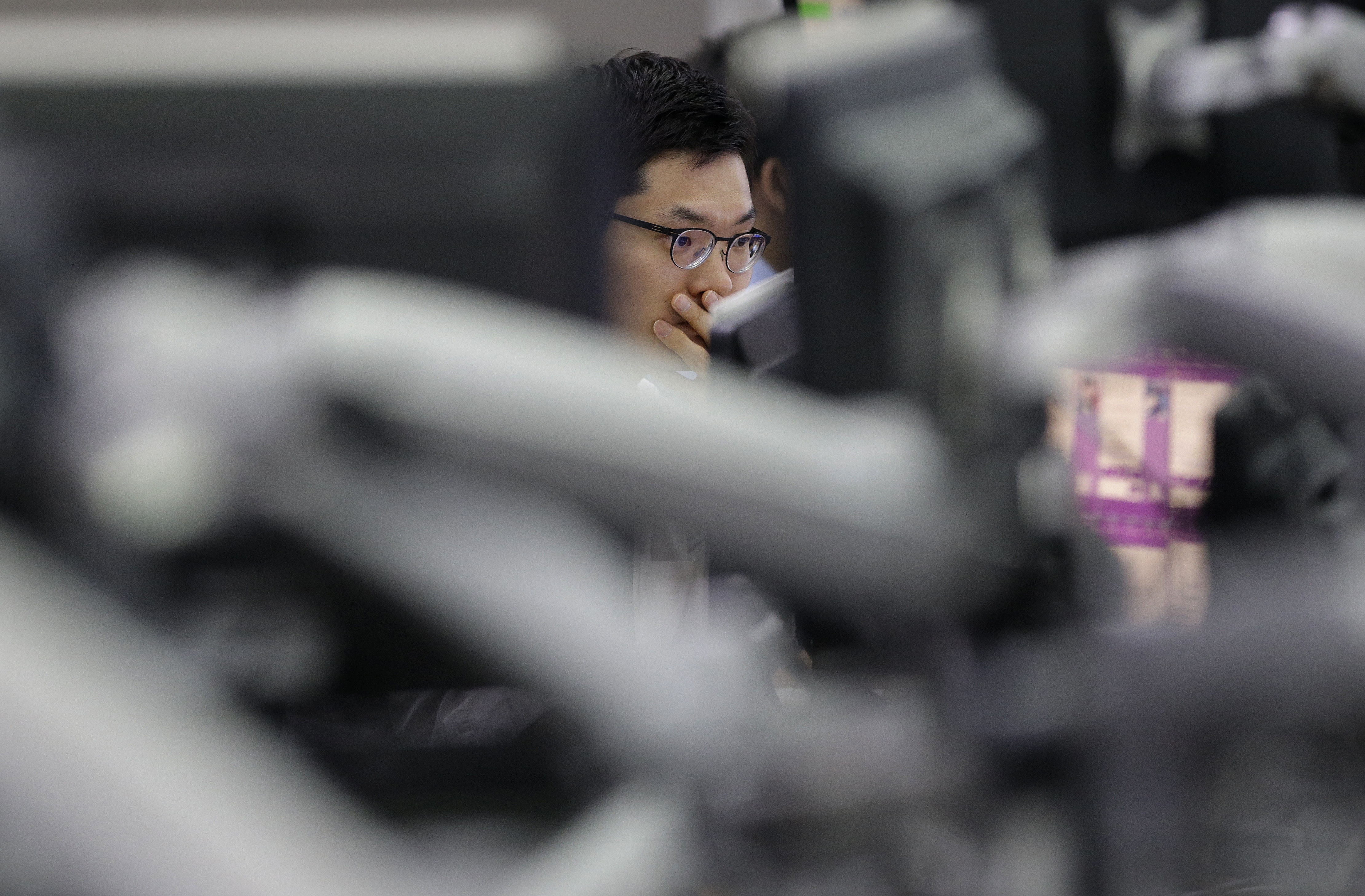 A currency trader peers at the monitor on his screen to check exchange rates. The yuan rebounded on Tuesday after Beijing said it would adopt the IMF's accounting rule. Photo: AP