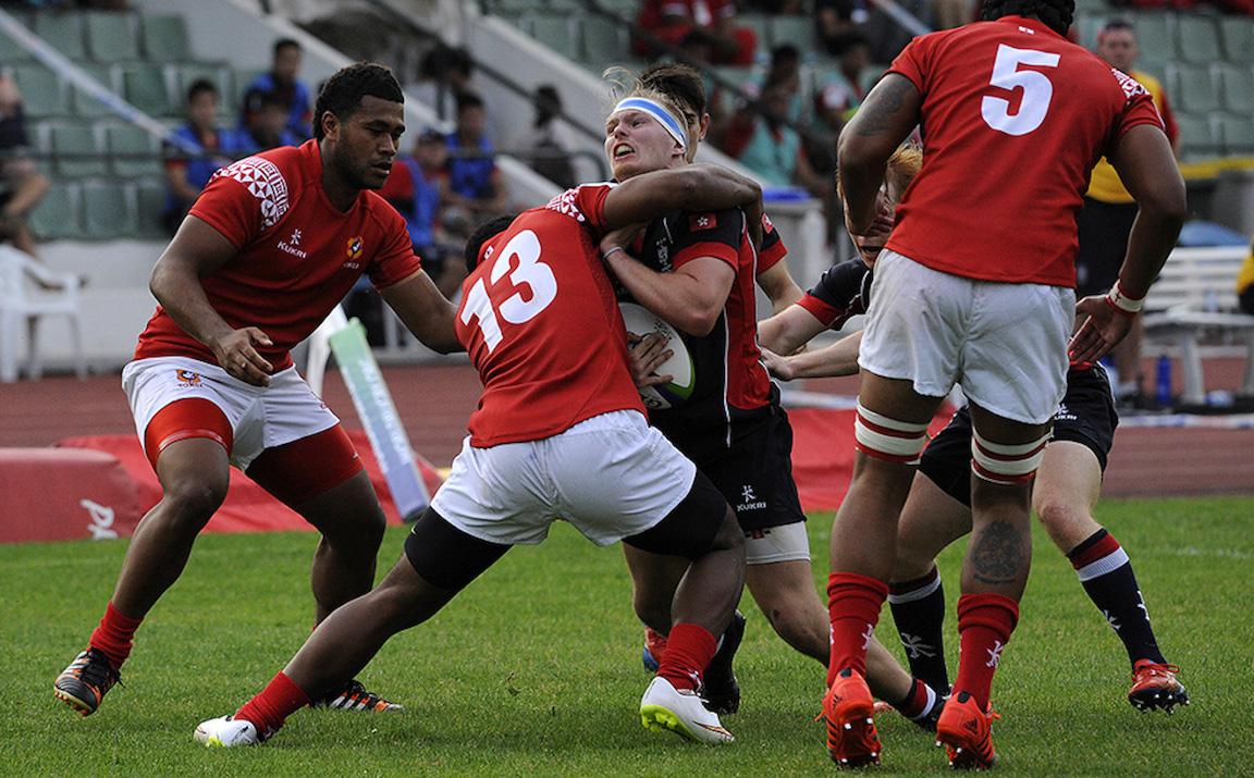 Hooker Alex Post gets wrapped up by the Tongan defence as Hong Kong open their 2015 Junior World Rugby Trophy campaign in defeat.  Photos: HKRFU