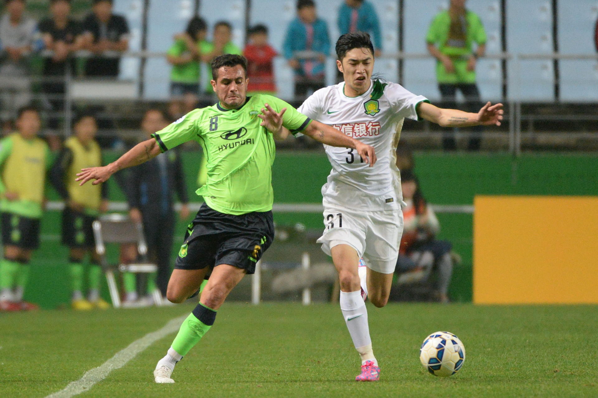 Jeonbuk Motors' Eninho grapples with Beijing Guoan's Zhao Hejing during the first leg of their last-16 tie in South Korea. Photo: Xinhua