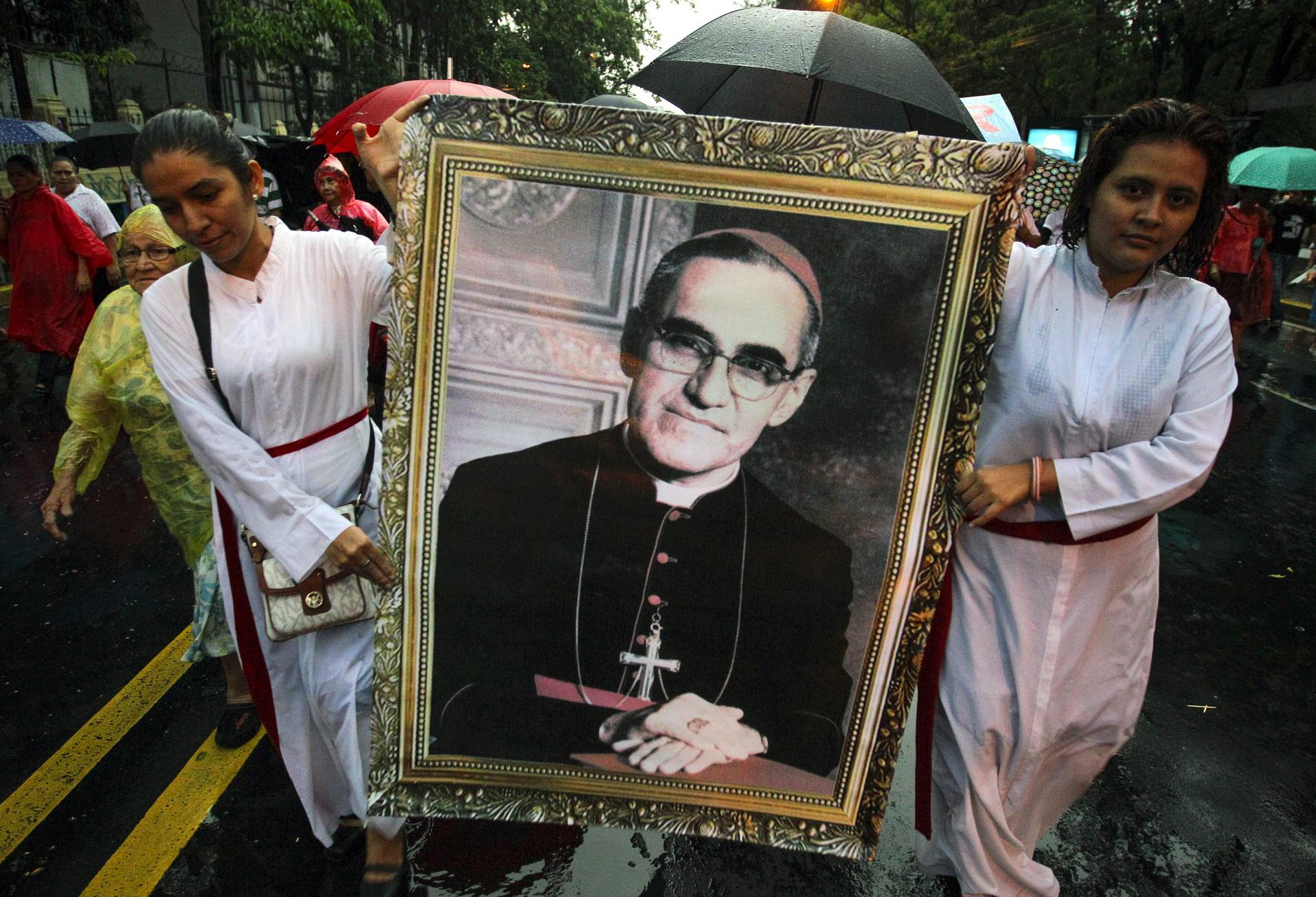 Devotees hold a portrait of the late Oscar Romero. Photo: EPA