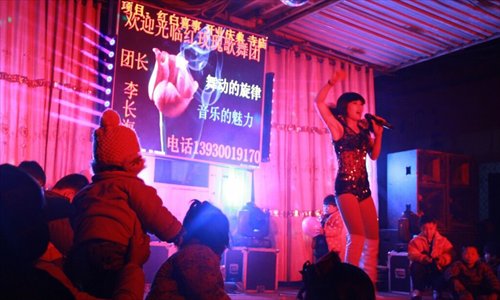 Villagers, including children, watching a strip show at a funeral in Hebei province. Photo: Global Times