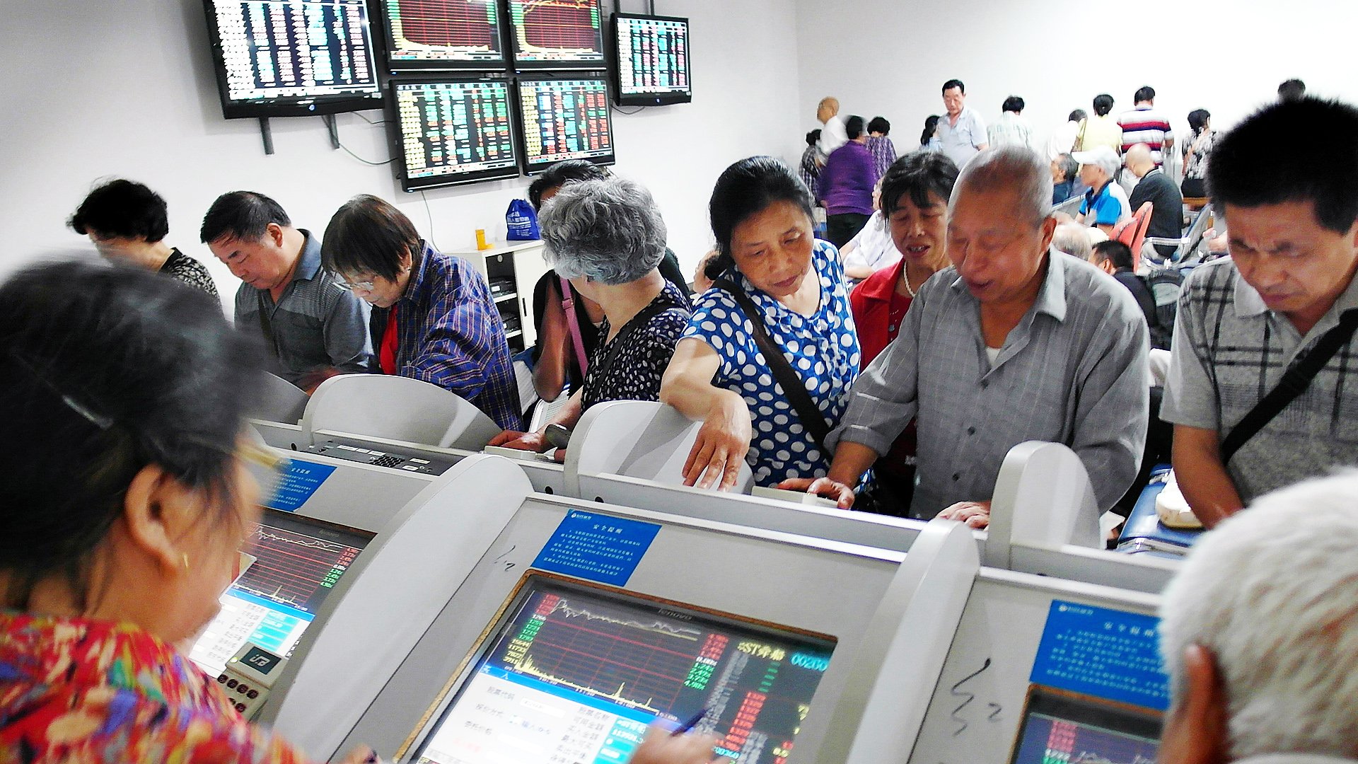 Investors look over stock prices on display terminals at a brokerage house in Yichang, Hubei province. Photo: AP