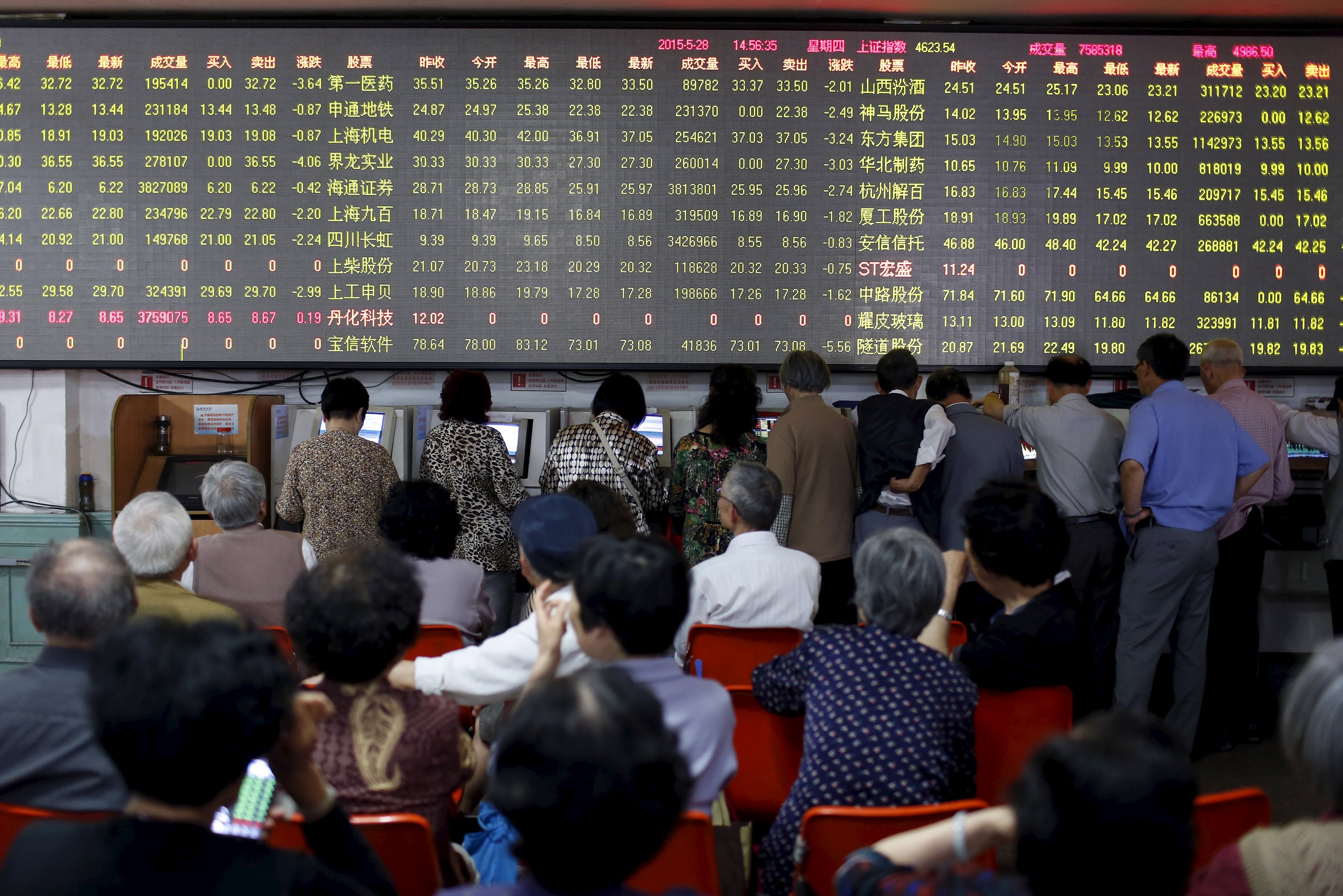 Investors in Shanghai monitor stock prices as punters piled in on surging share values as the fear of missing out on the next big thing spurred buying in Chinese markets. Photo: Reuters