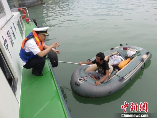 A patrol officer questions Tang who was found paddling in the Three Gorges Dam. Photo: China News