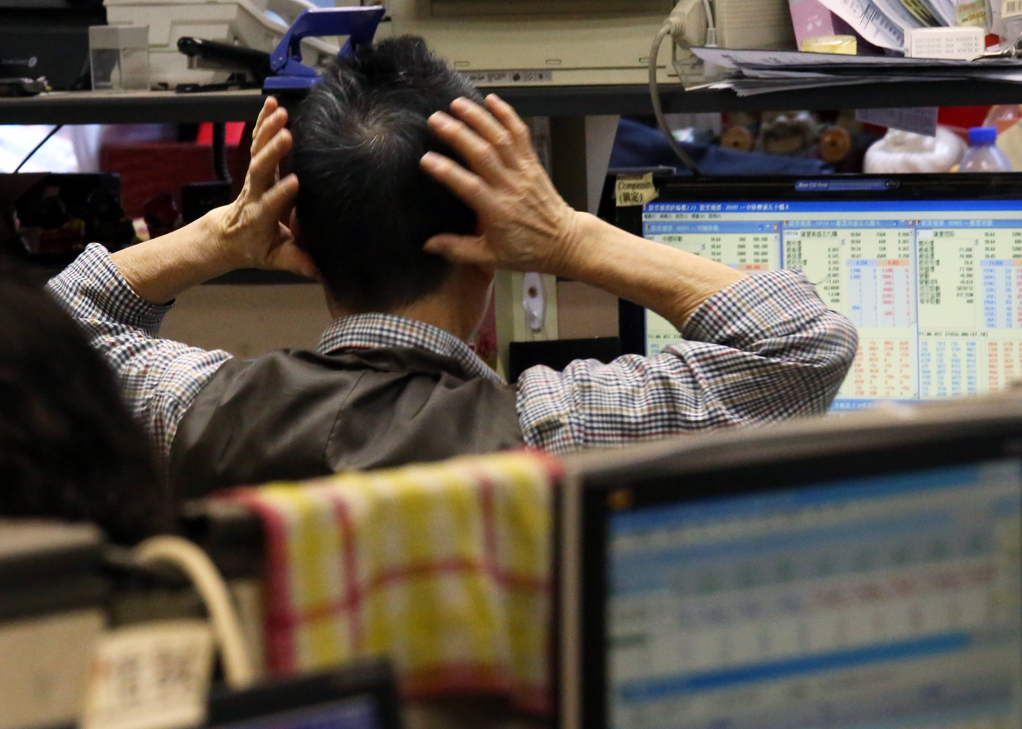 A trader in Hong Kong grabs his head in consternation. The exchange operator, Hong Kong Exchanges and Clearing, is putting in a system to fight the sharp volatility caused by high-frequency traders. Photo: Nora Tam