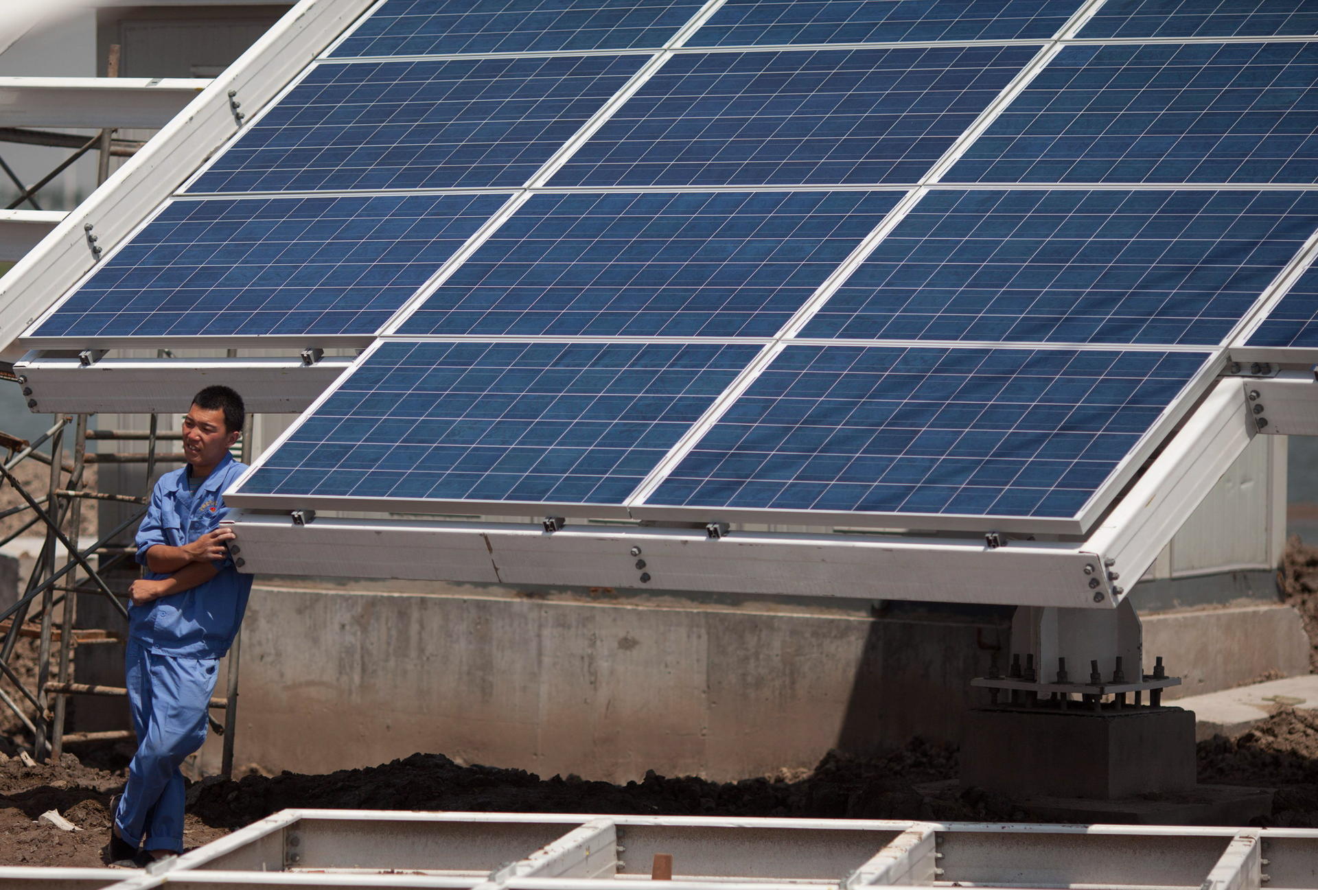A worker takes a break from installing solar panels near the eco-city in Tianjin. Photo: AFP