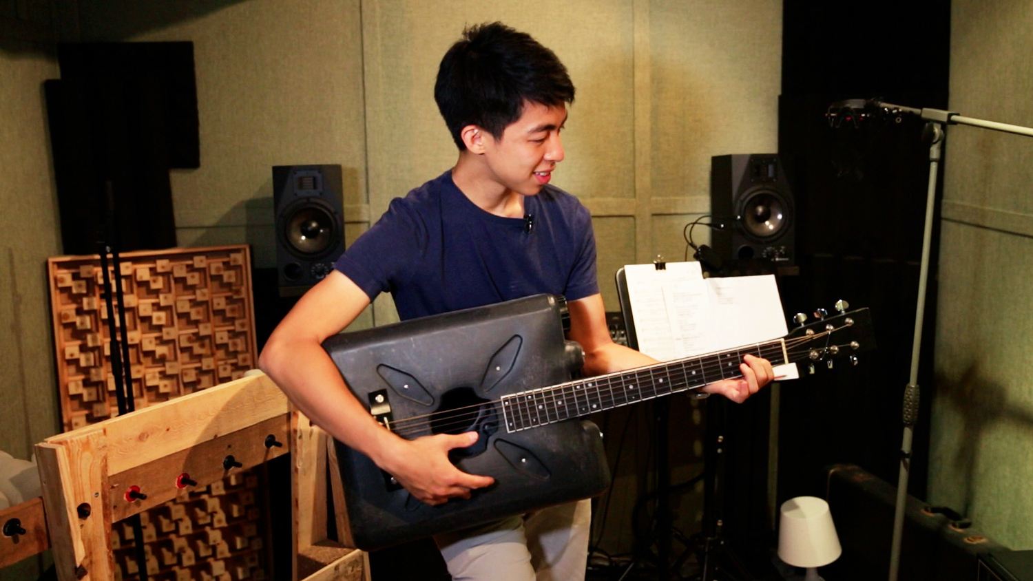 Kevin Cheung holds the guitar he made from a discarded plastic bottle. 