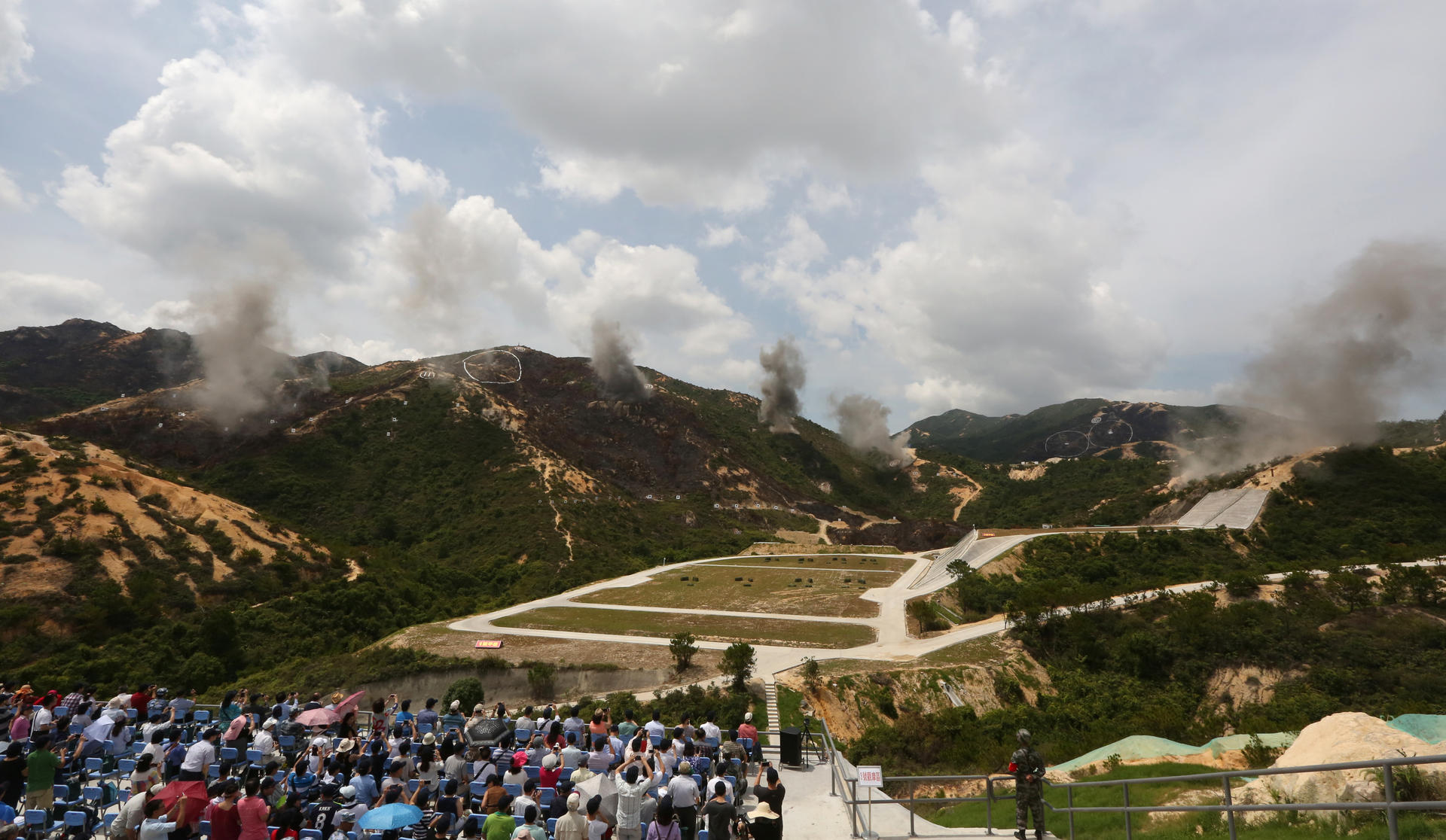 Guests and local media watched the PLA Hong Kong Garrison conduct a military exercise against 'terrorists' at Castle Peak firing range at Tuen Mun. Photo: Felix Wong