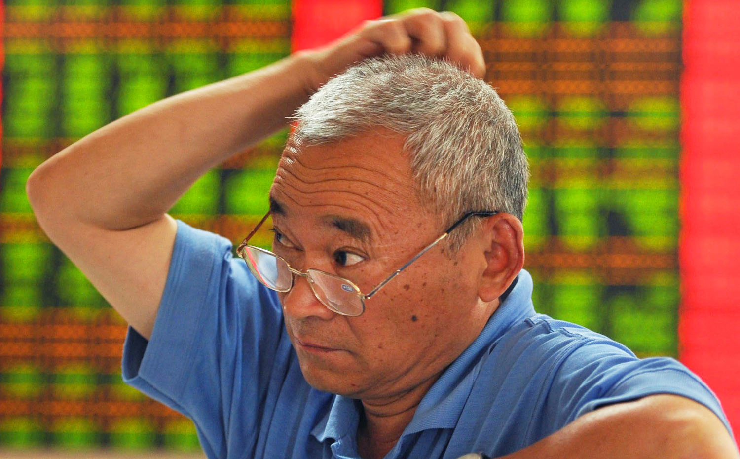 A Chinese investor scratches his head as stocks plummet in Shanghai and Shenzhen. Photo: EPA 