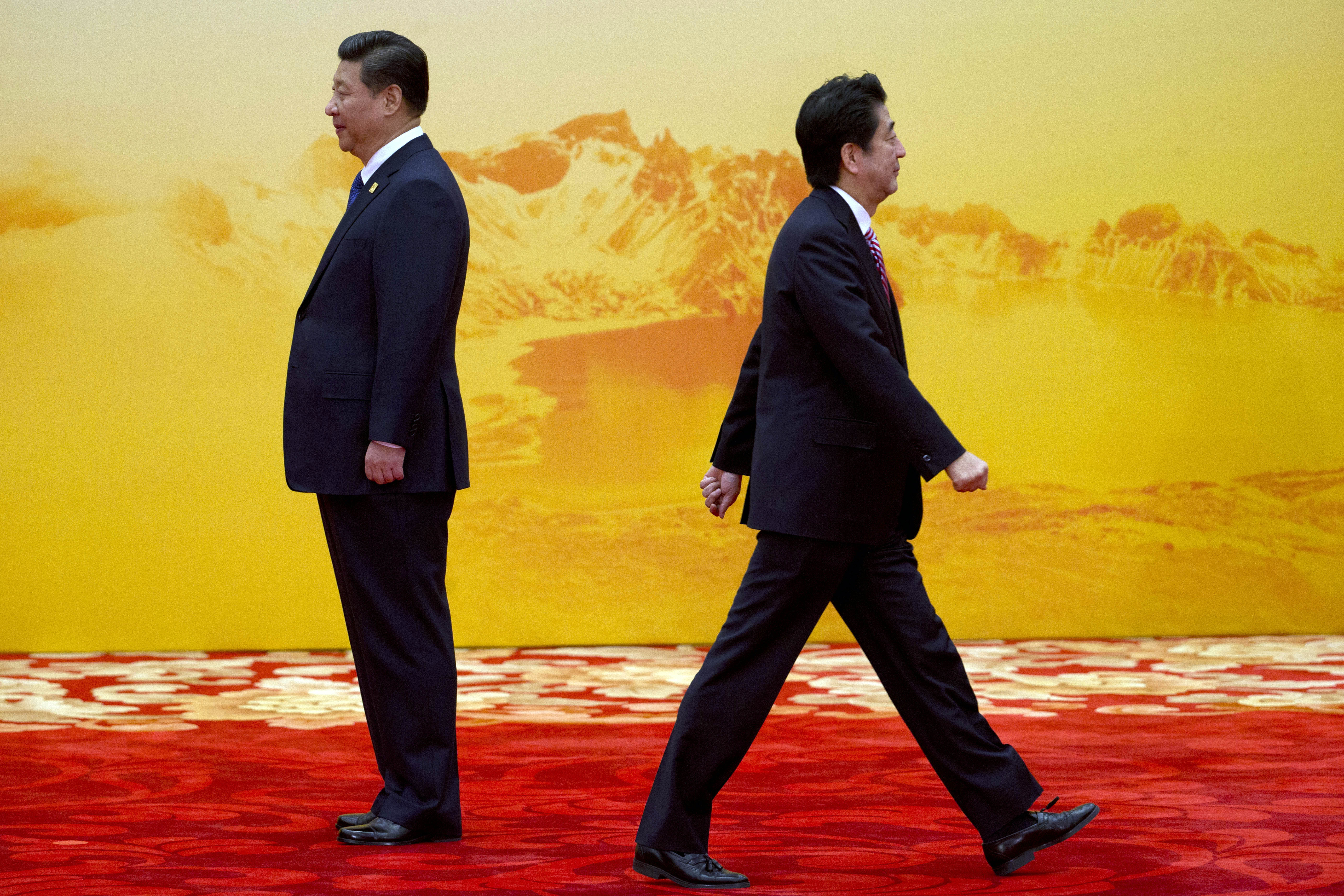 Japan's Prime Minister Shinzo Abe walks past Chinese President Xi Jinping during last year's Asia-Pacific Economic Cooperation summit at Beijing, China. Photo: AP