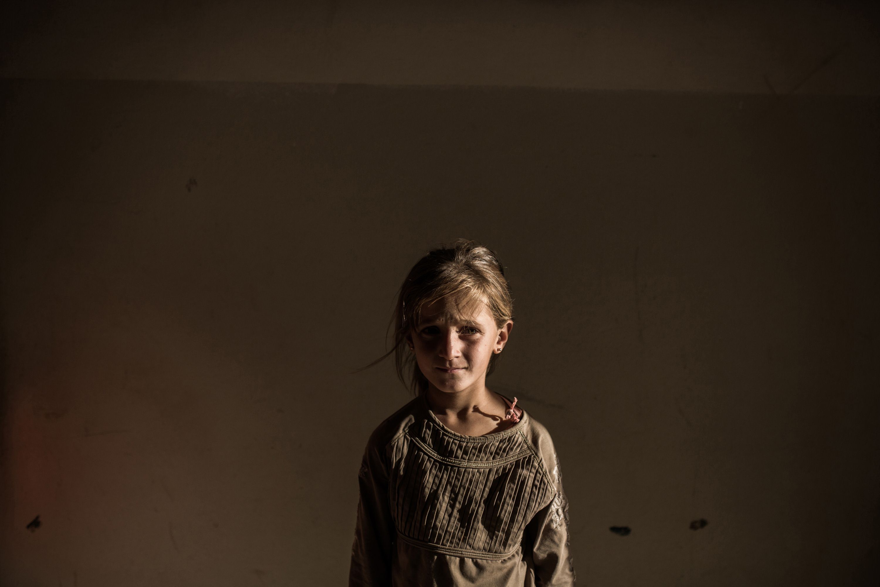 A Syrian refugee girl stands in a building in the Syrian Kurdish city of Amuda, after running away from clashes between regime forces and Islamic State. Photo: AFP
