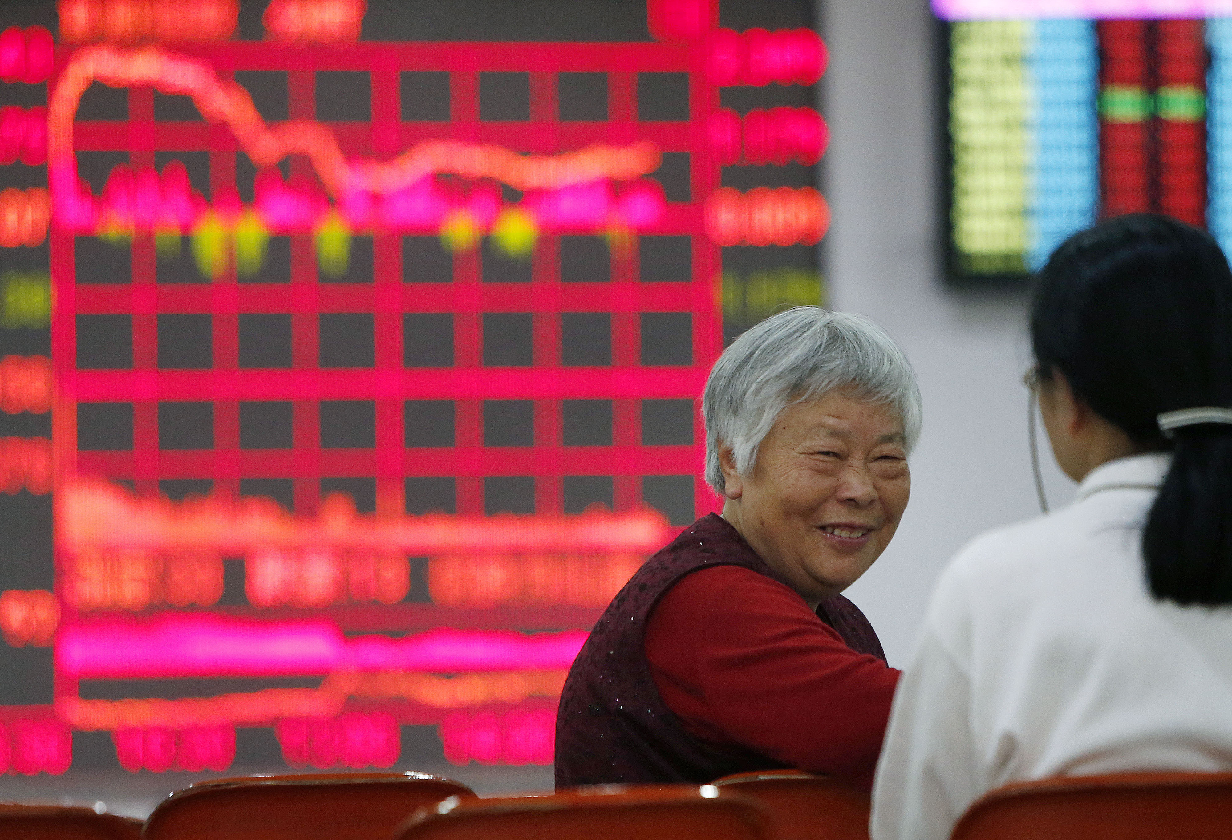 Chinese investors exchange notes as analysts warn a recent rout in equities may not be over. Photo: Xinhua