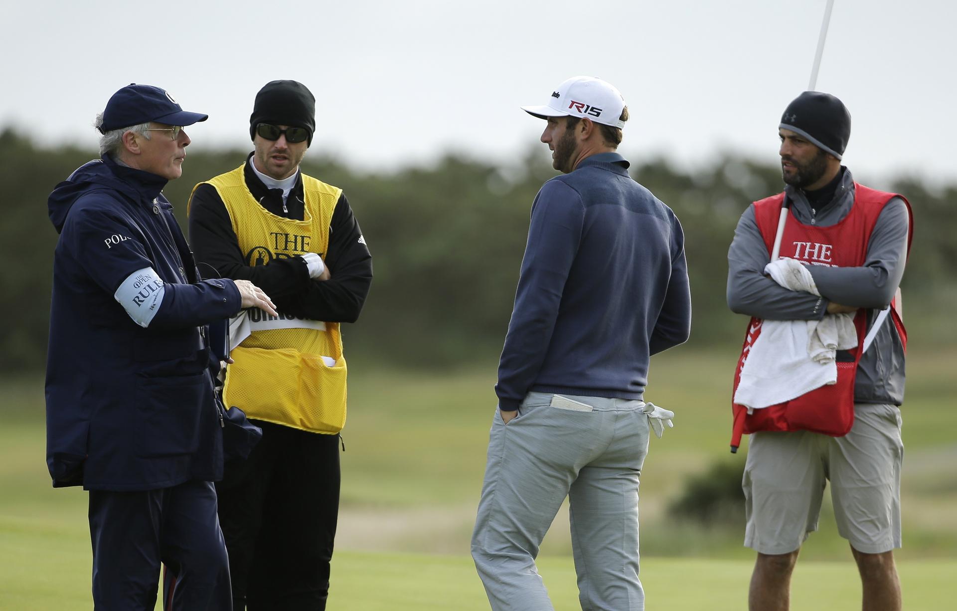 Dustin Johnson speaks with officials as play is suspended.Photo: AP