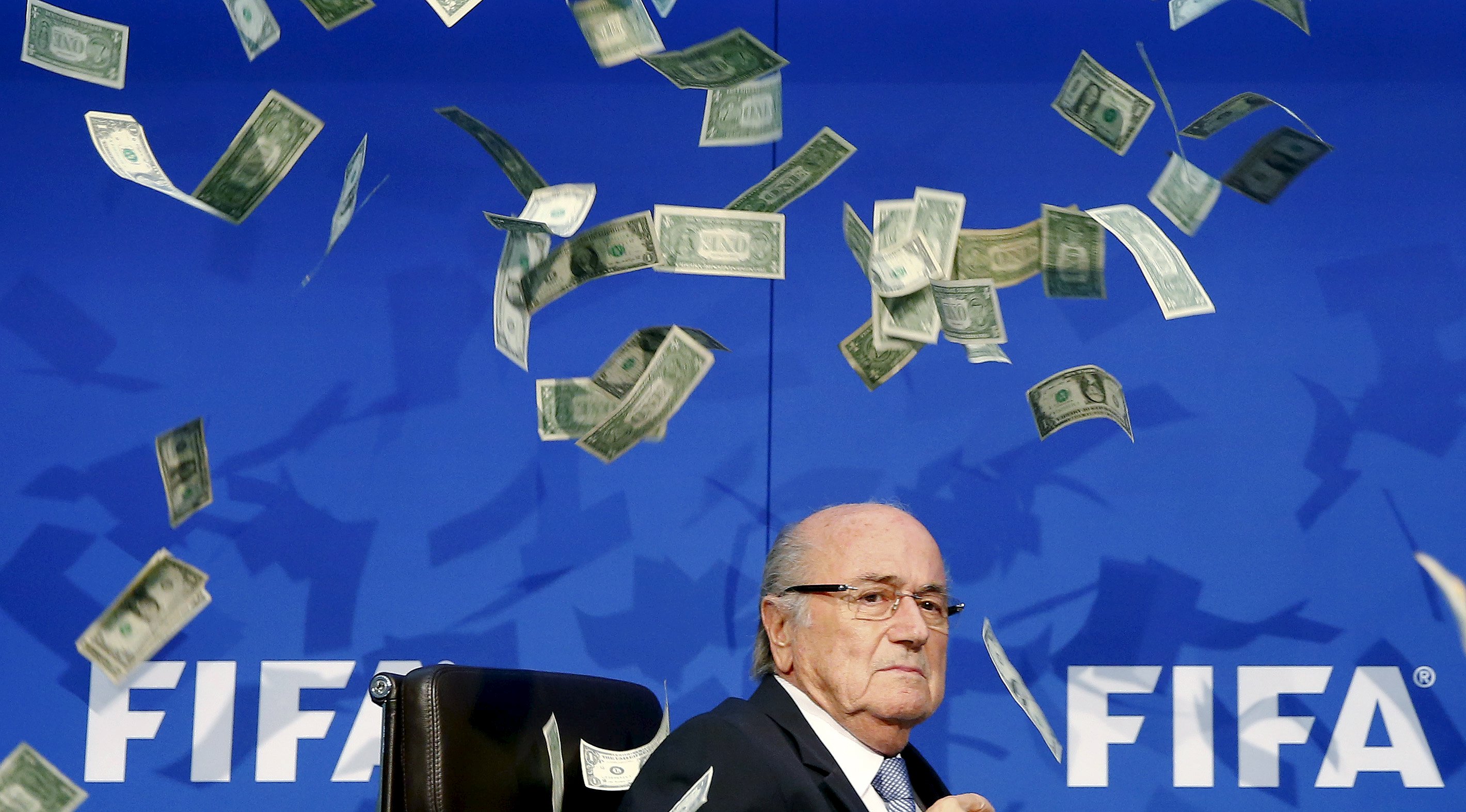 Comedian Simon Brodkin (unseen) throws fake dollars at Blatter. Photo: Reuters
