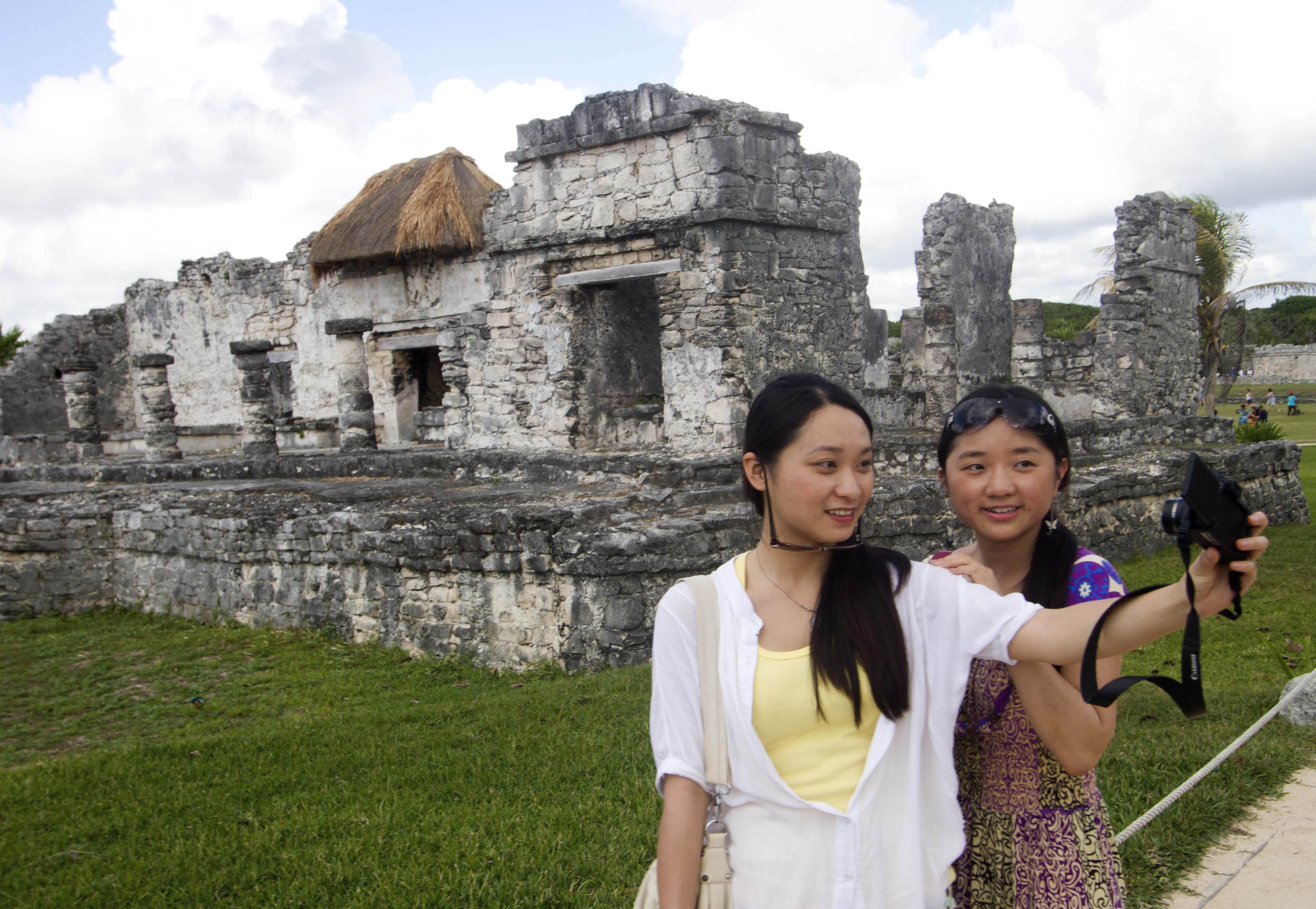 Chinese tourists take selfies of themselves in Cancun, Mexico, as a surge in travel could benefit the shares of online travel agencies like Ctrip and Qunar. Photo: AFP