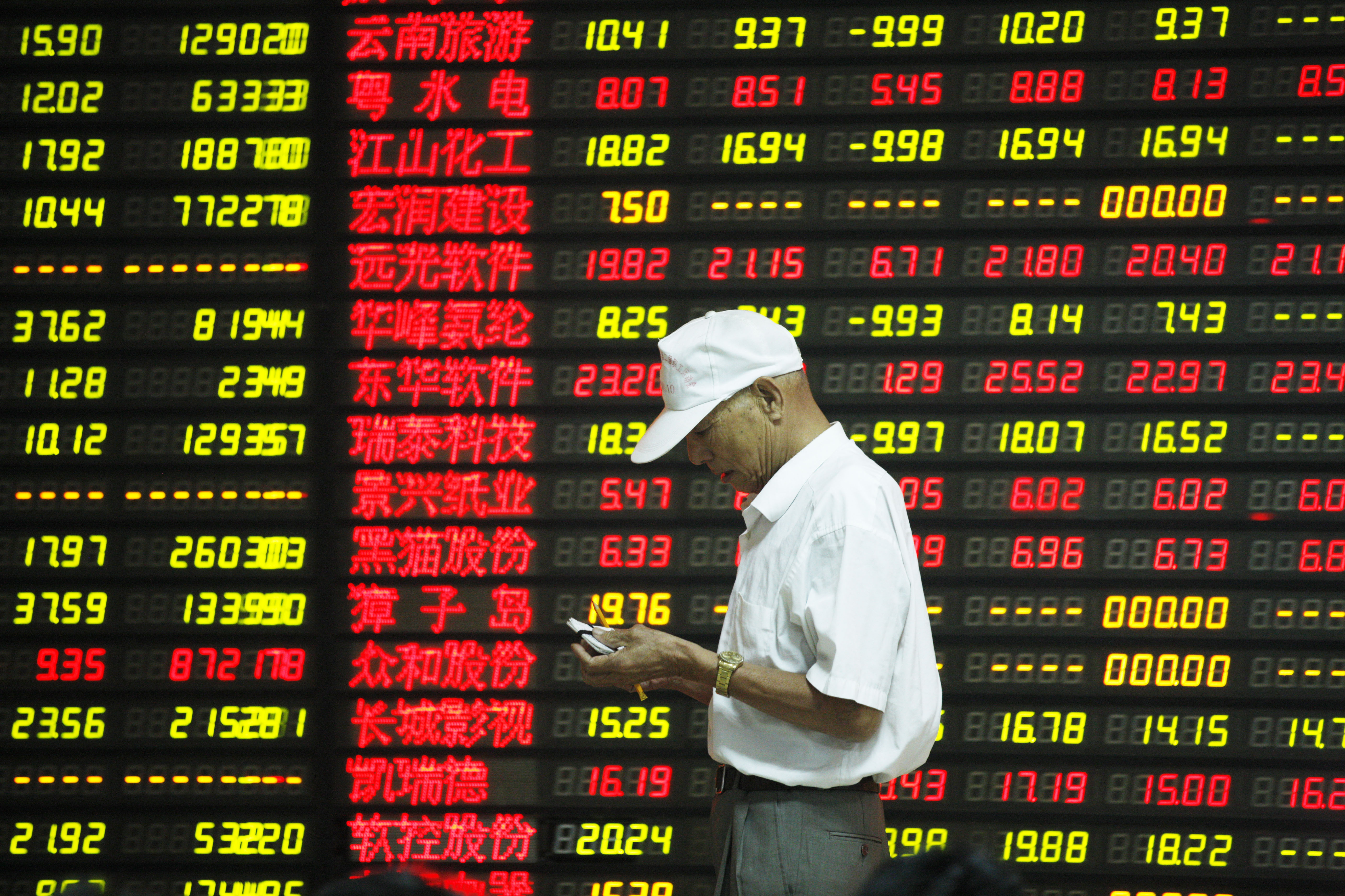 A Chinese investor jots down stock prices as equities in the mainland and in Hong Kong are looking at another choppy week in trading. Photo: Xinhua