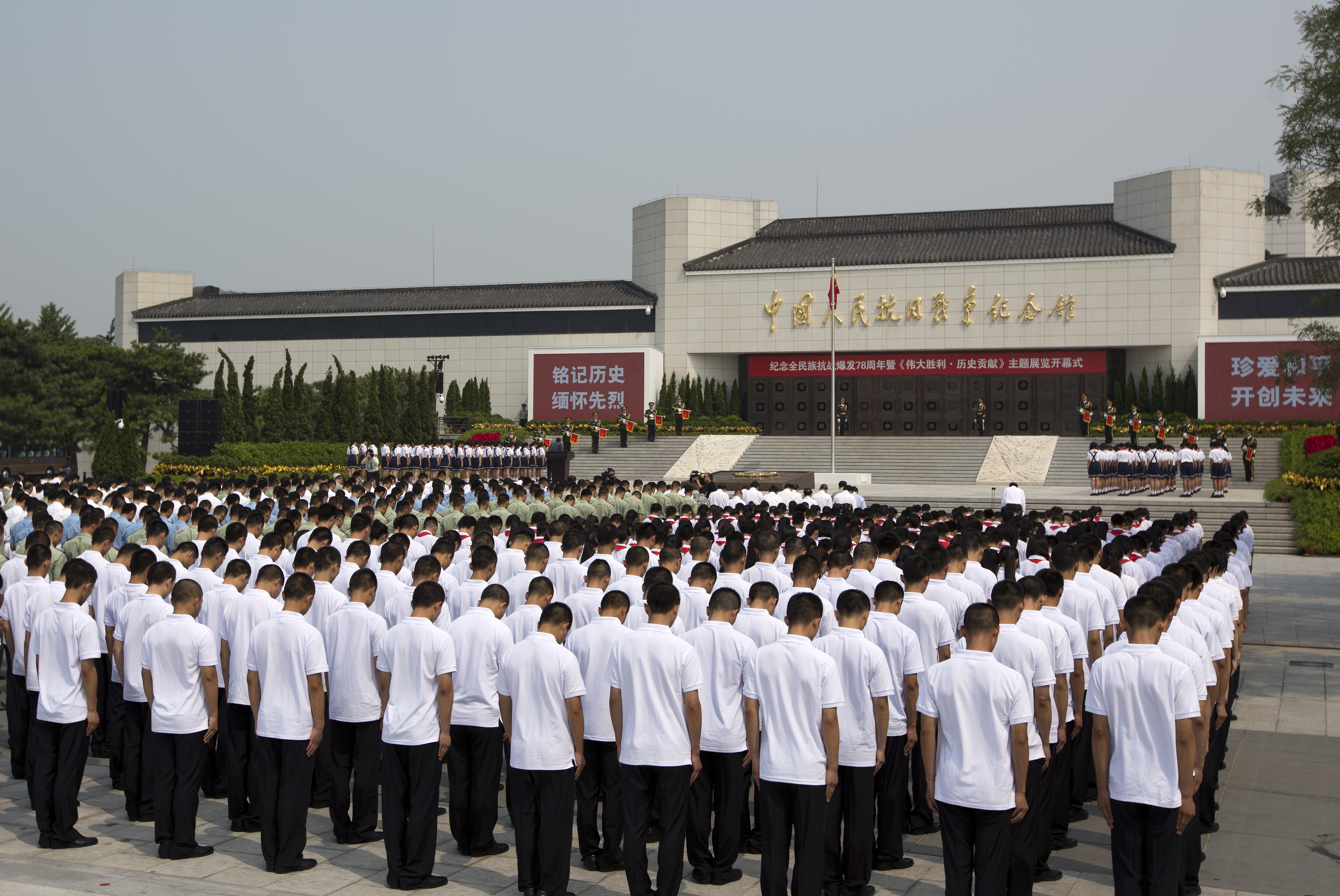 Chinese soldiers and students bow during a commemoration service outside the Museum of the War of Chinese People's Resistance Against Japanese Aggression, in Beijing. Photo: AP