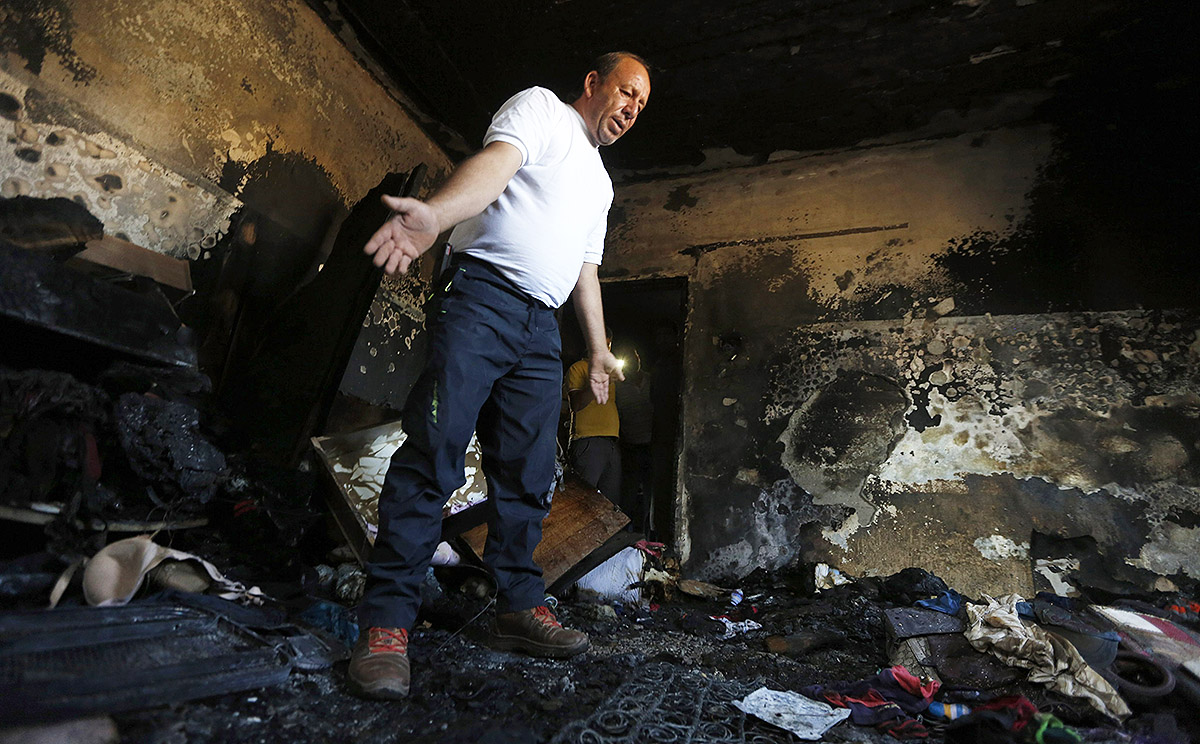 A Palestinian man checks the fire damage to a relative's house in the West Bank village of Douma near Nablus City on the West Bank. Photo: EPA