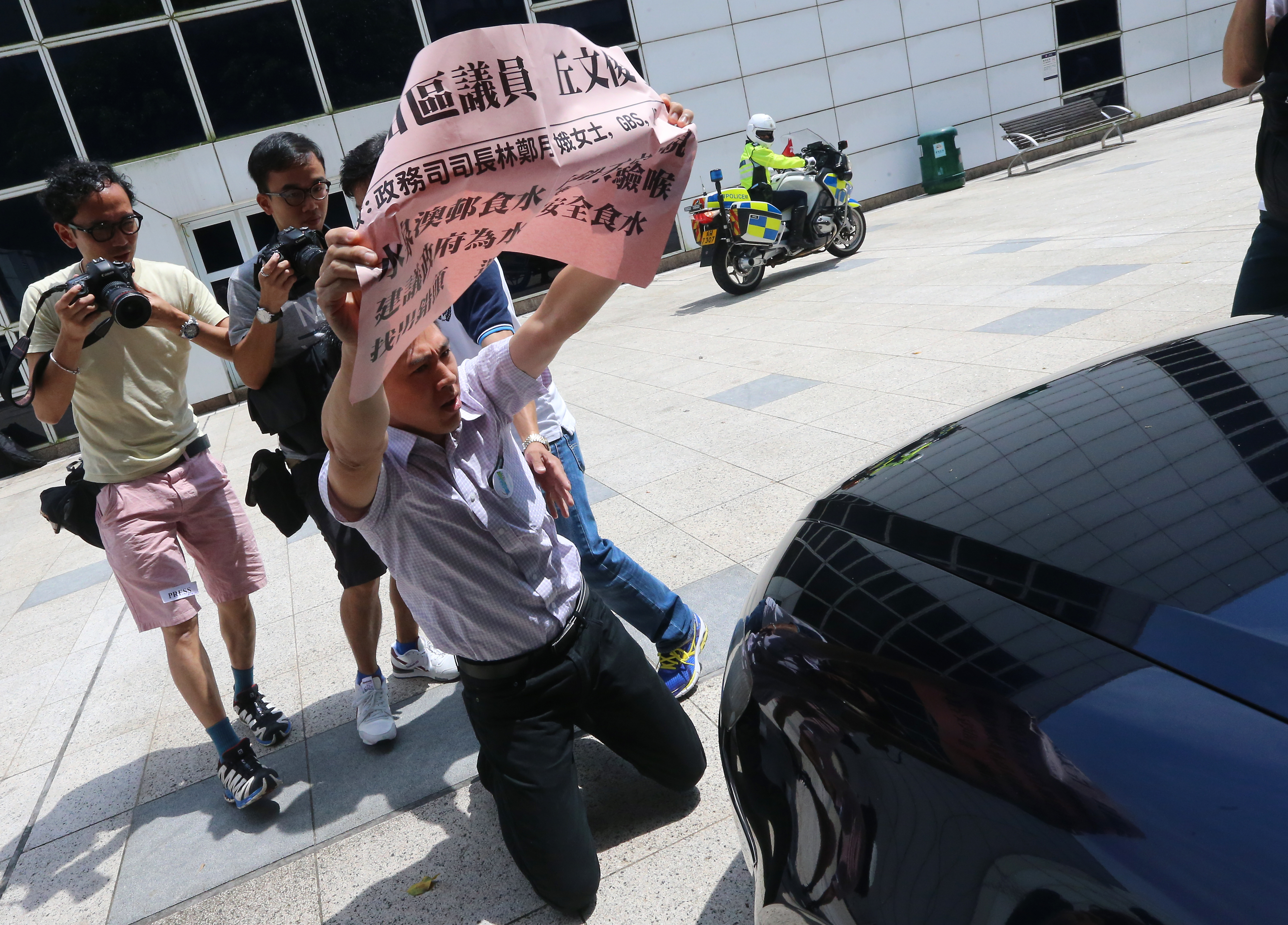 Sha Tin District Council member Yau Man-chun kneel in front of Carrie Lam's car urging the government to test water lead level for Shui Chuen O Estate. Photo: David Wong