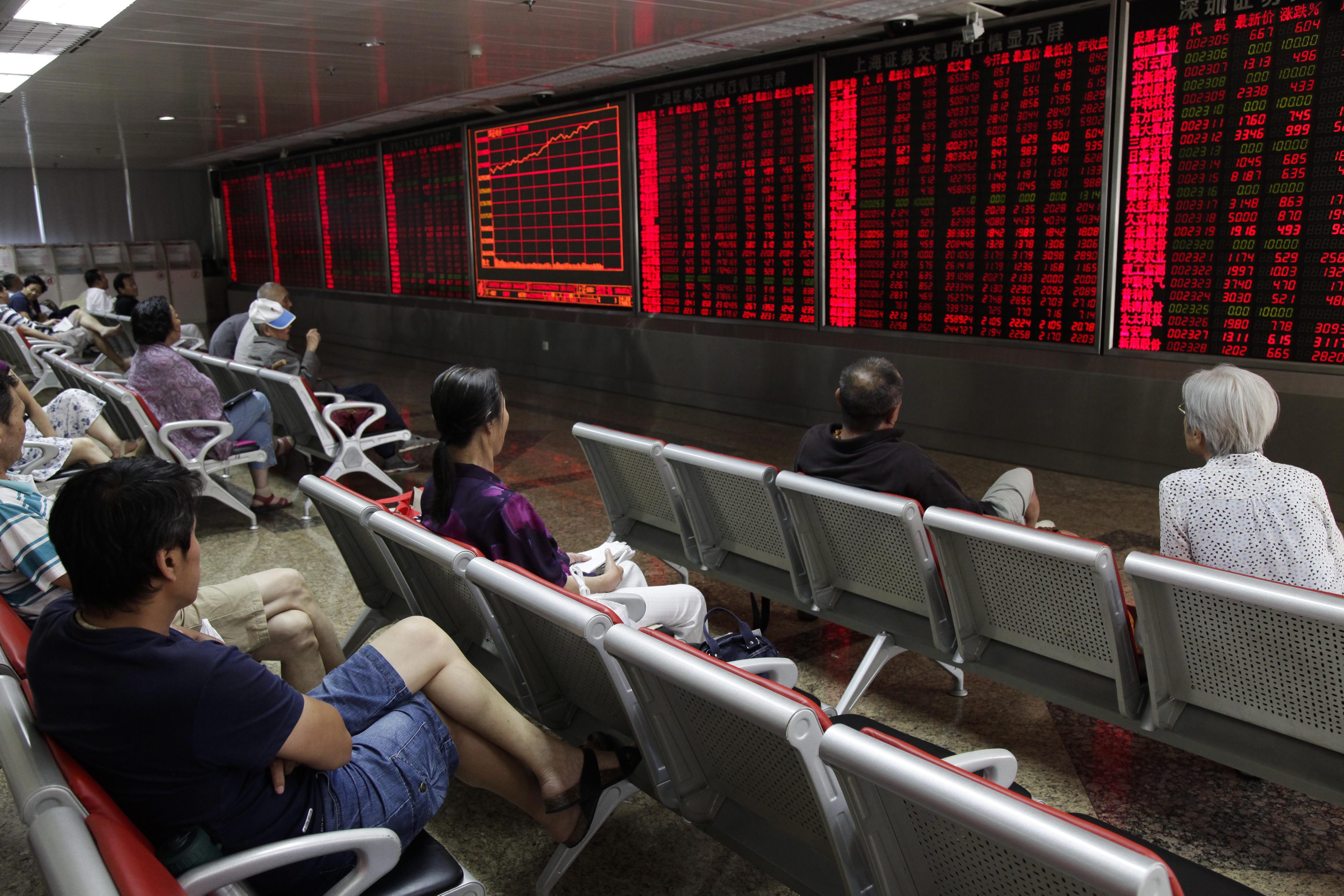 Investors in China's stock markets stare at an electronic board on stock prices as ADRs listed in the US face a complicated task to relist in markets in Shanghai and Shenzhen. Photo: EPA