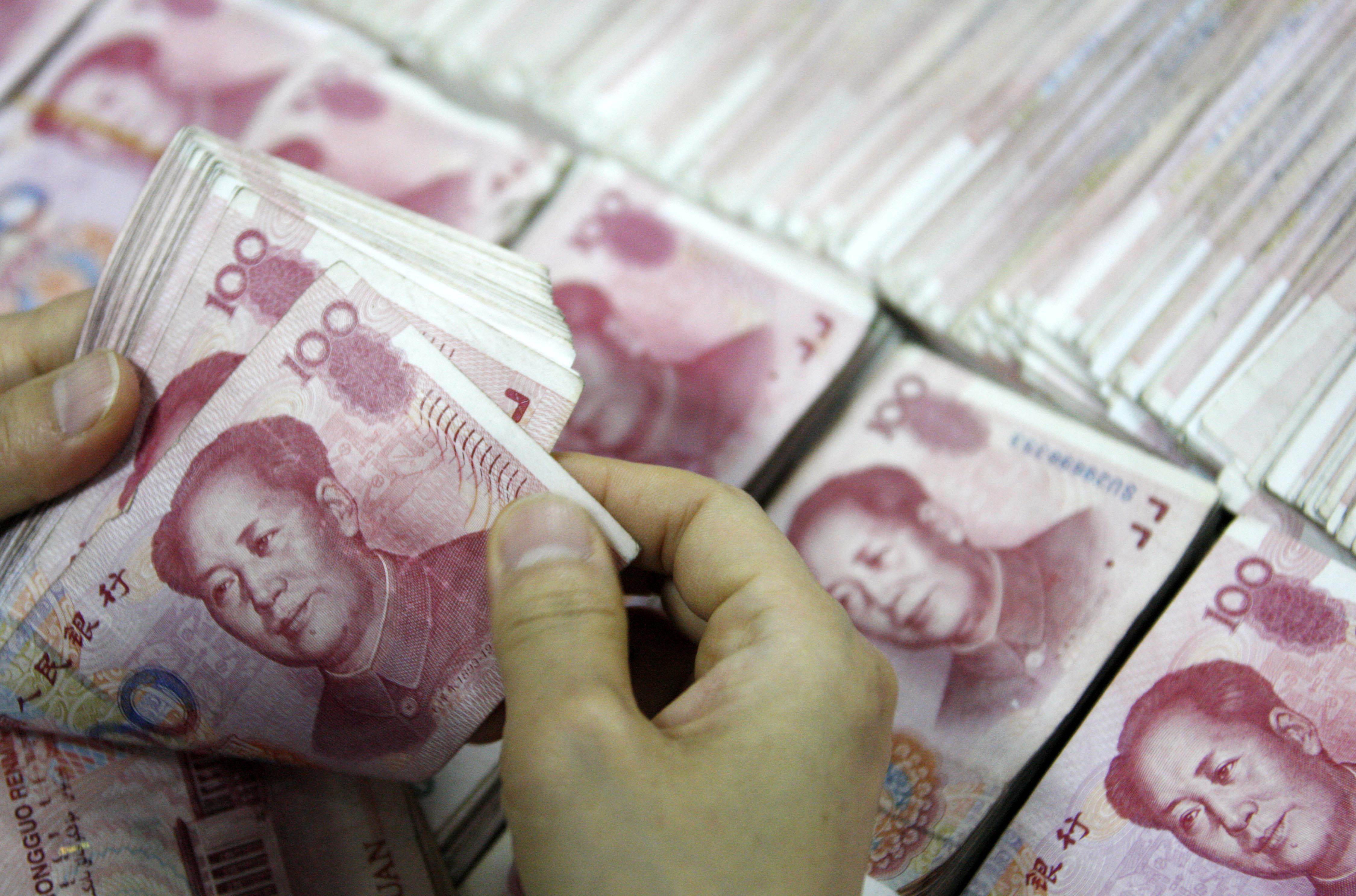 Stacks of yuan are counted at a bank in China as the currency has apparently stabilized after falling the past three days following a surprise devaluation earlier in the week. Photo: AFP