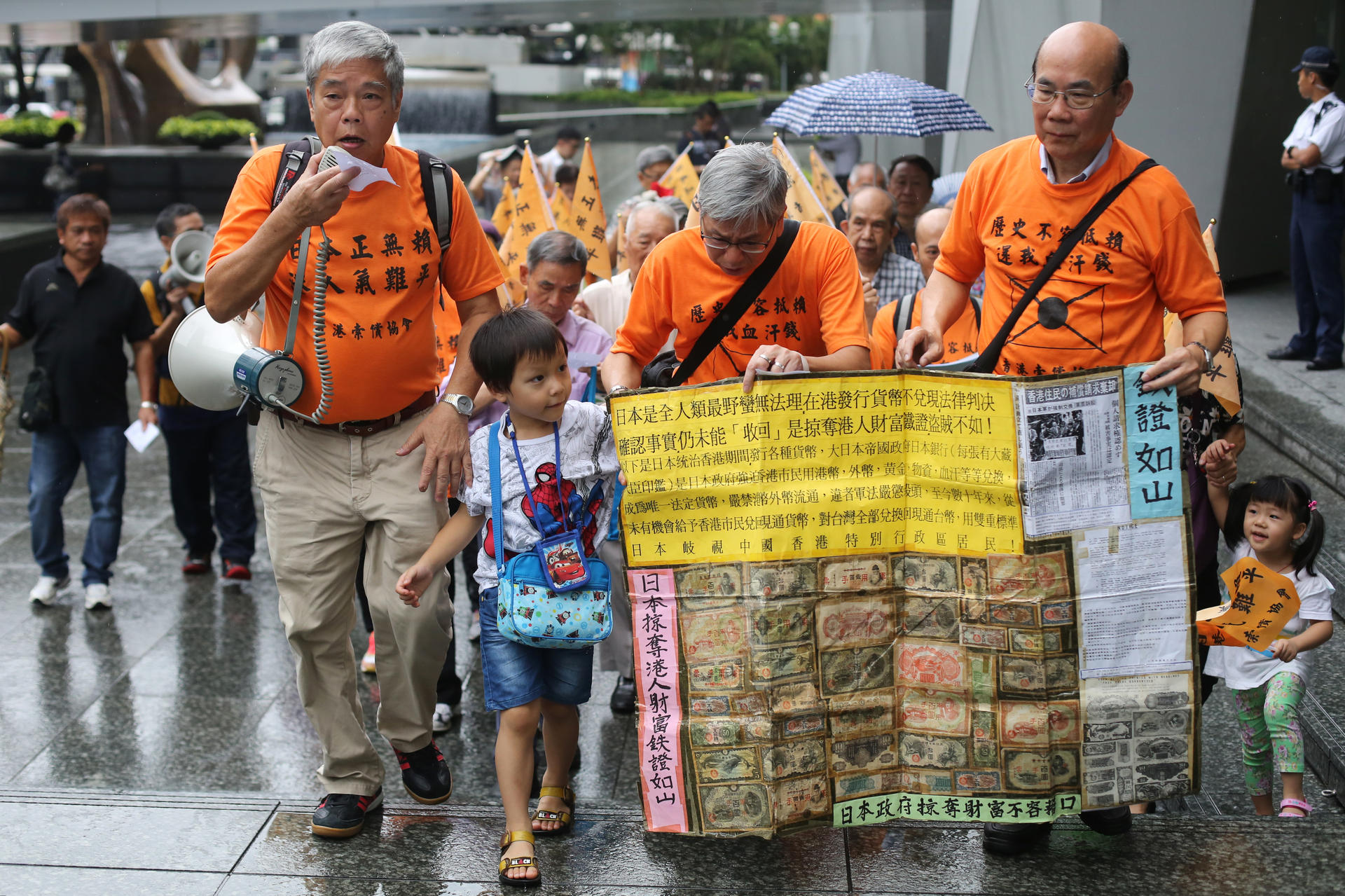 Around 20 members of the Hong Kong Reparation Association display wartime banknotes during a protest outside the Japanese consulate in Central yesterday.Photo: Sam Tsang