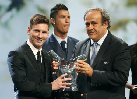 Barcelona's Lionel Messi receives his award from Uefa  president Michel Platini for the best player in Europe as Cristiano Ronaldo looks on at Monaco's Grimaldi Forum. Photo: Reuters 