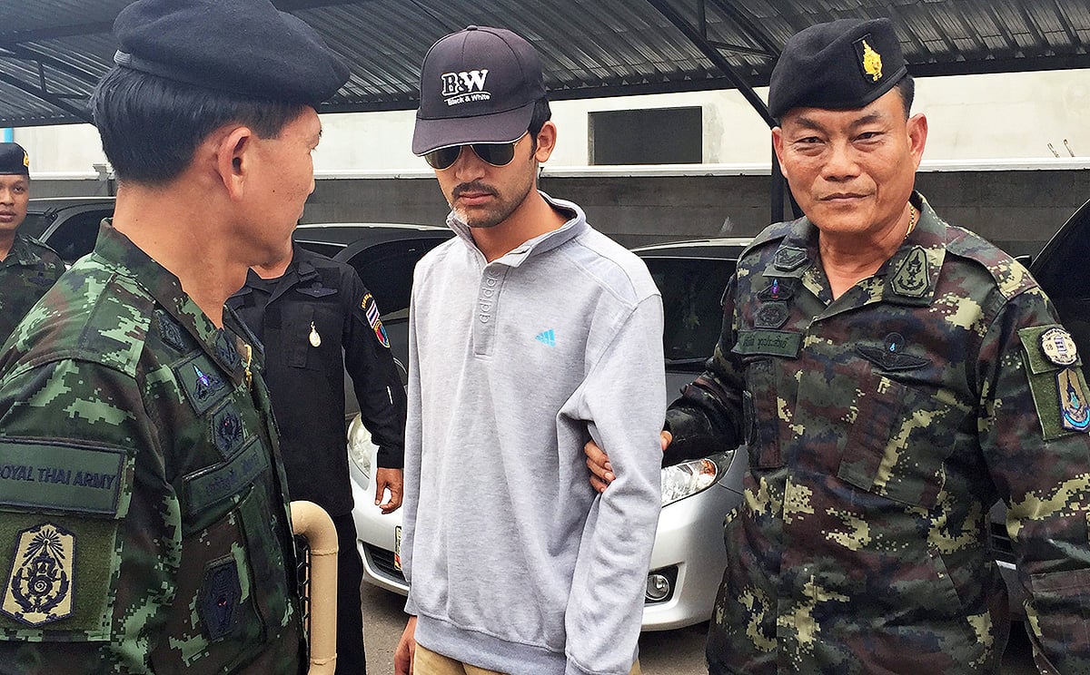 Royal Thai Army soldiers escort the Erawan Shrine bombing suspect after they arrested him in Sa Kaeo district, near the Thai-Cambodian border on Tuesday.  Local media said the suspect was being flown back to Bangkok by helicopter to be interrogated by authorities. Photo: EPA