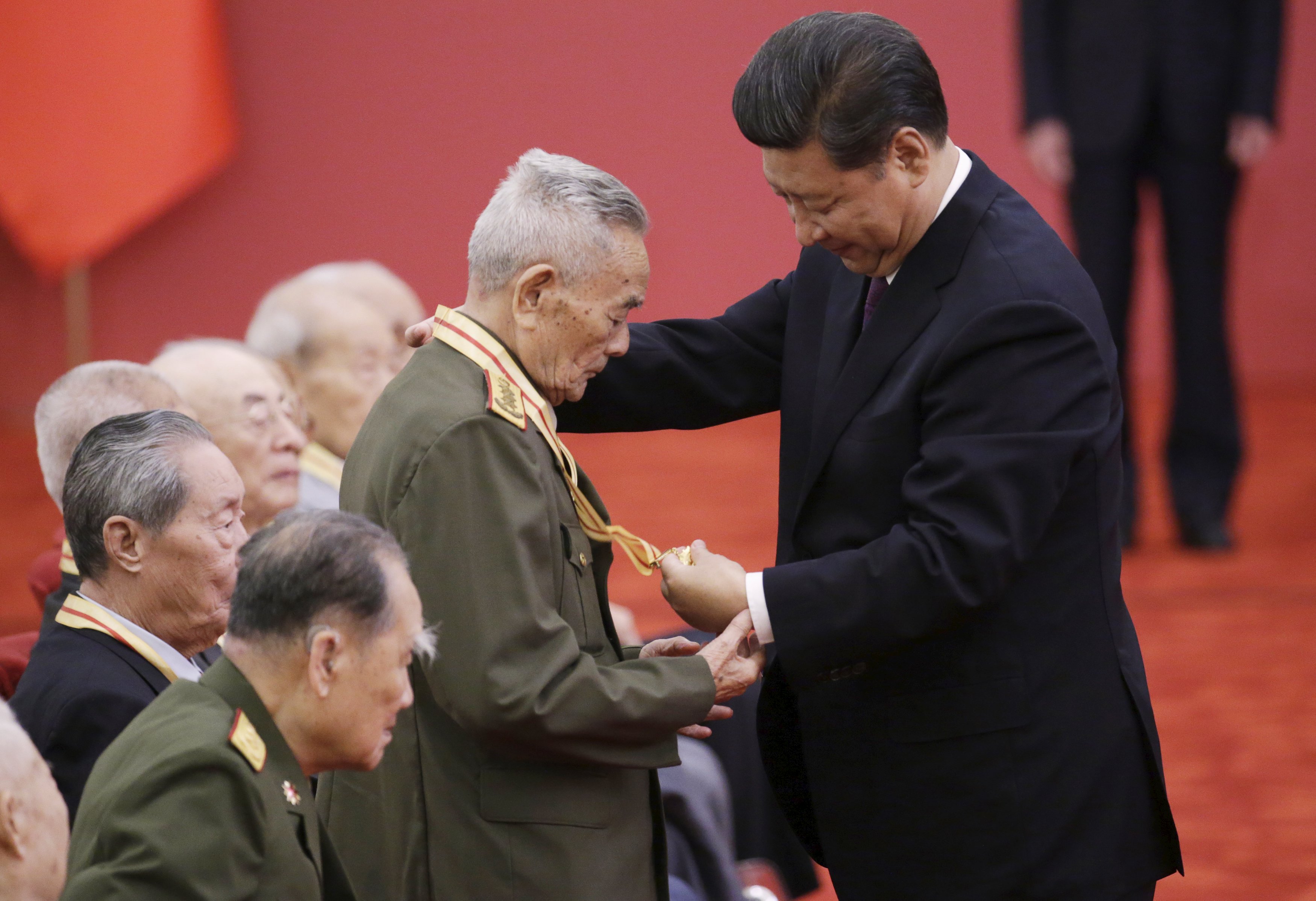 President Xi Jinping and a war veteran look at a commemorative medal at a medal ceremony at the Great Hall of the People in Beijing. Photo: Reuters