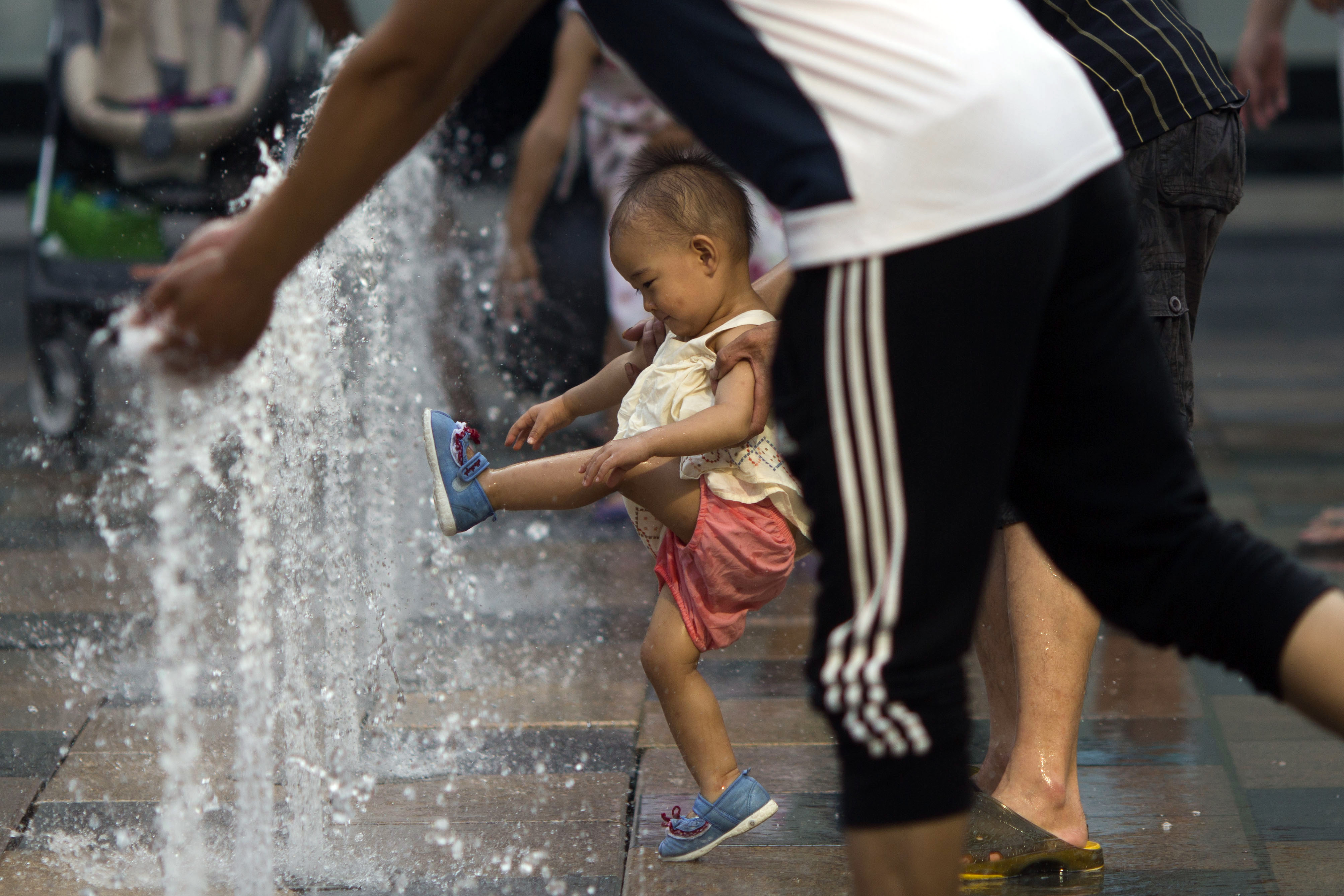 A child plays near a water fountain at a mall in Beijing. Photo: AP
