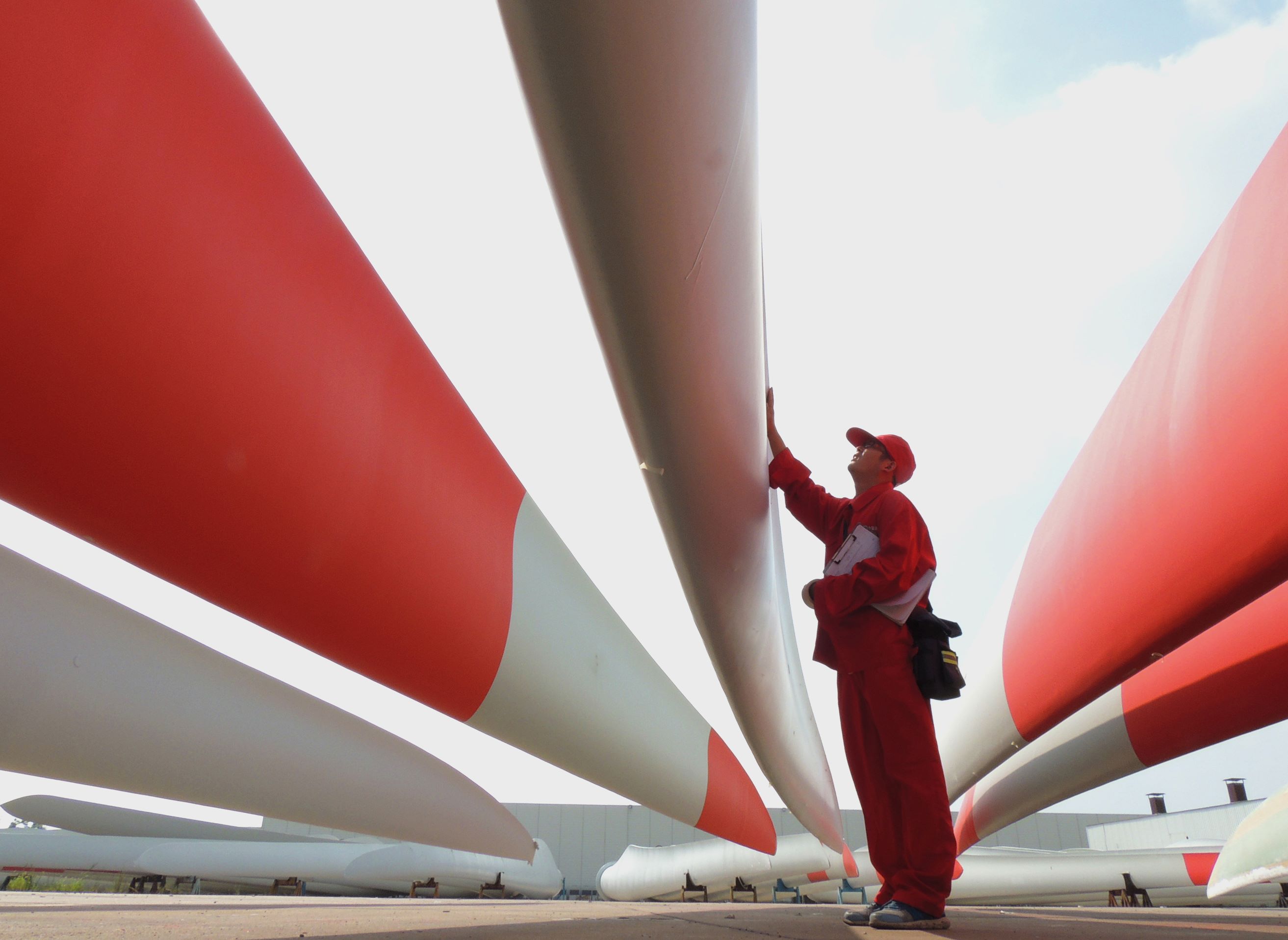 A worker checks the quality of the blades of wind turbines in a factory in Lianyungang, Jiangsu province. Photo: AFP