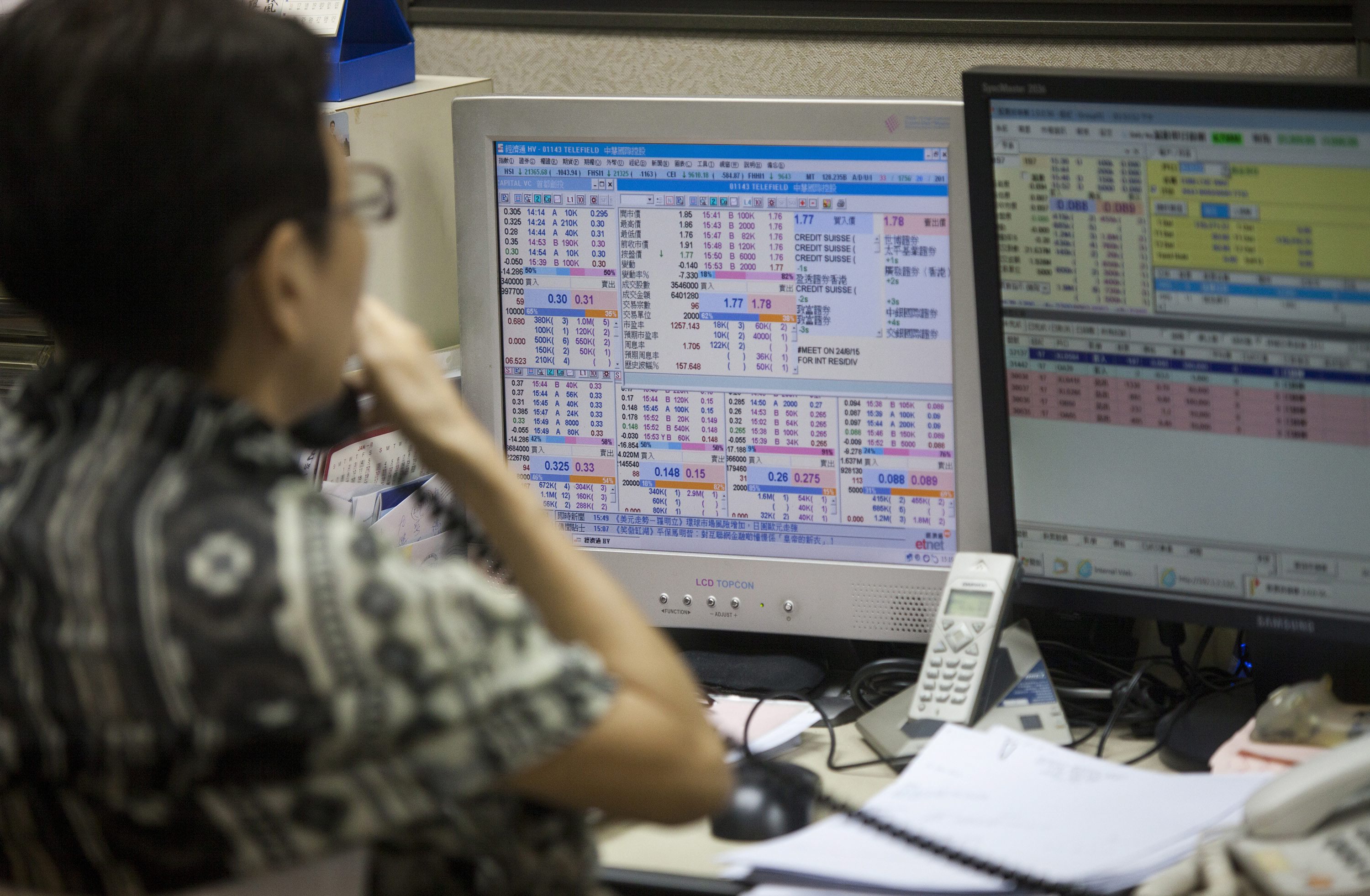 A stock broker operates at a trading house as the Hang Seng Index falls  during Thursday's action. Photo: EPA