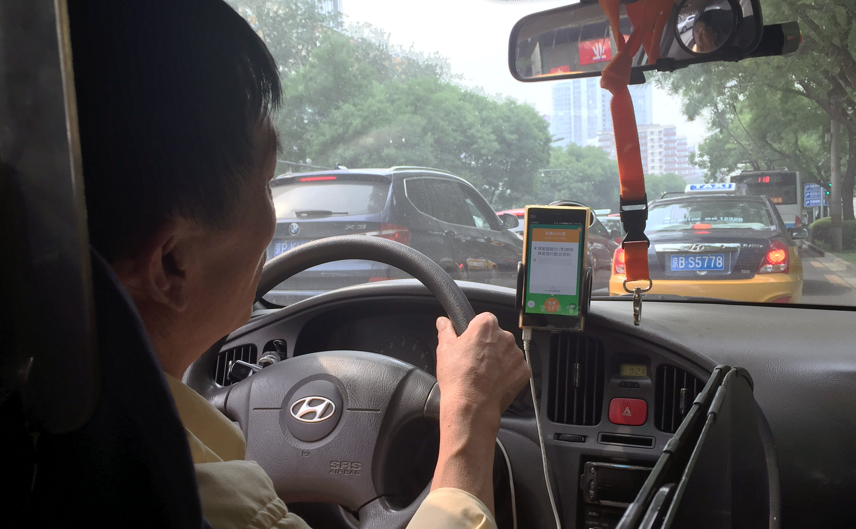 A taxi driver in Beijing takes a request from a taxi-hailing app. Now the Chinese government seems to be muscling on such apps by creating their own. Photo: Simon Song