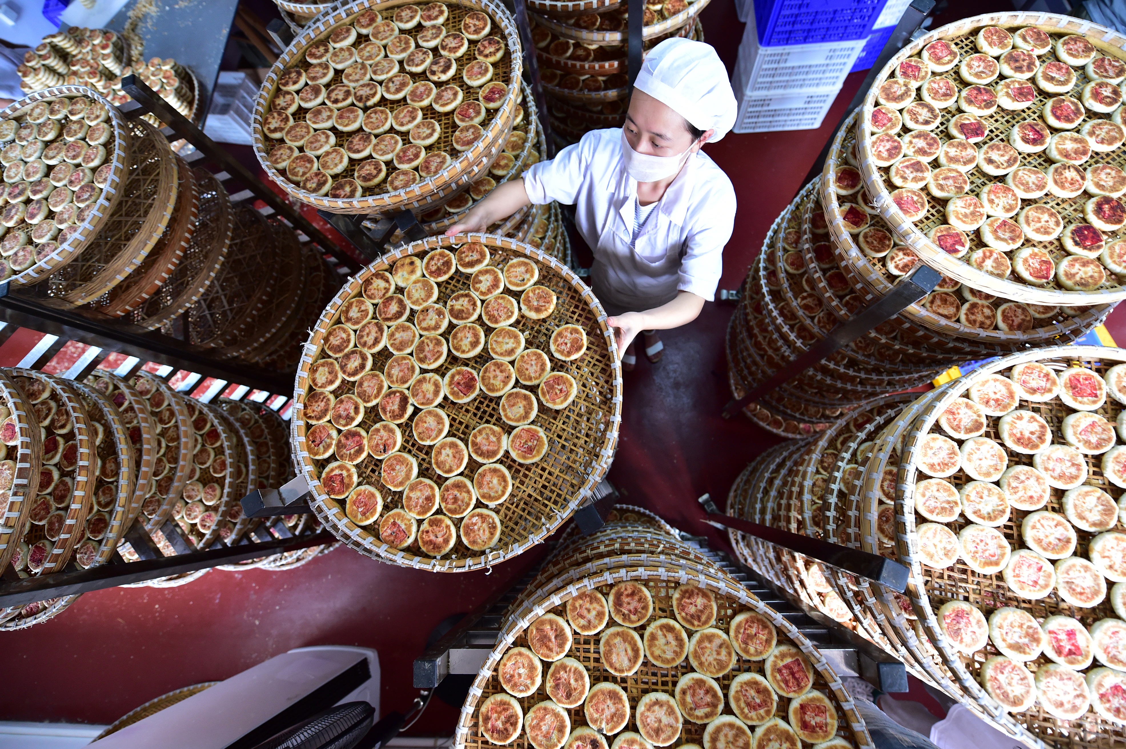 A worker at Yiting Supply and Marketing Cooperatives Food Factory lets baked mooncakes cool. Photo: Xinhua