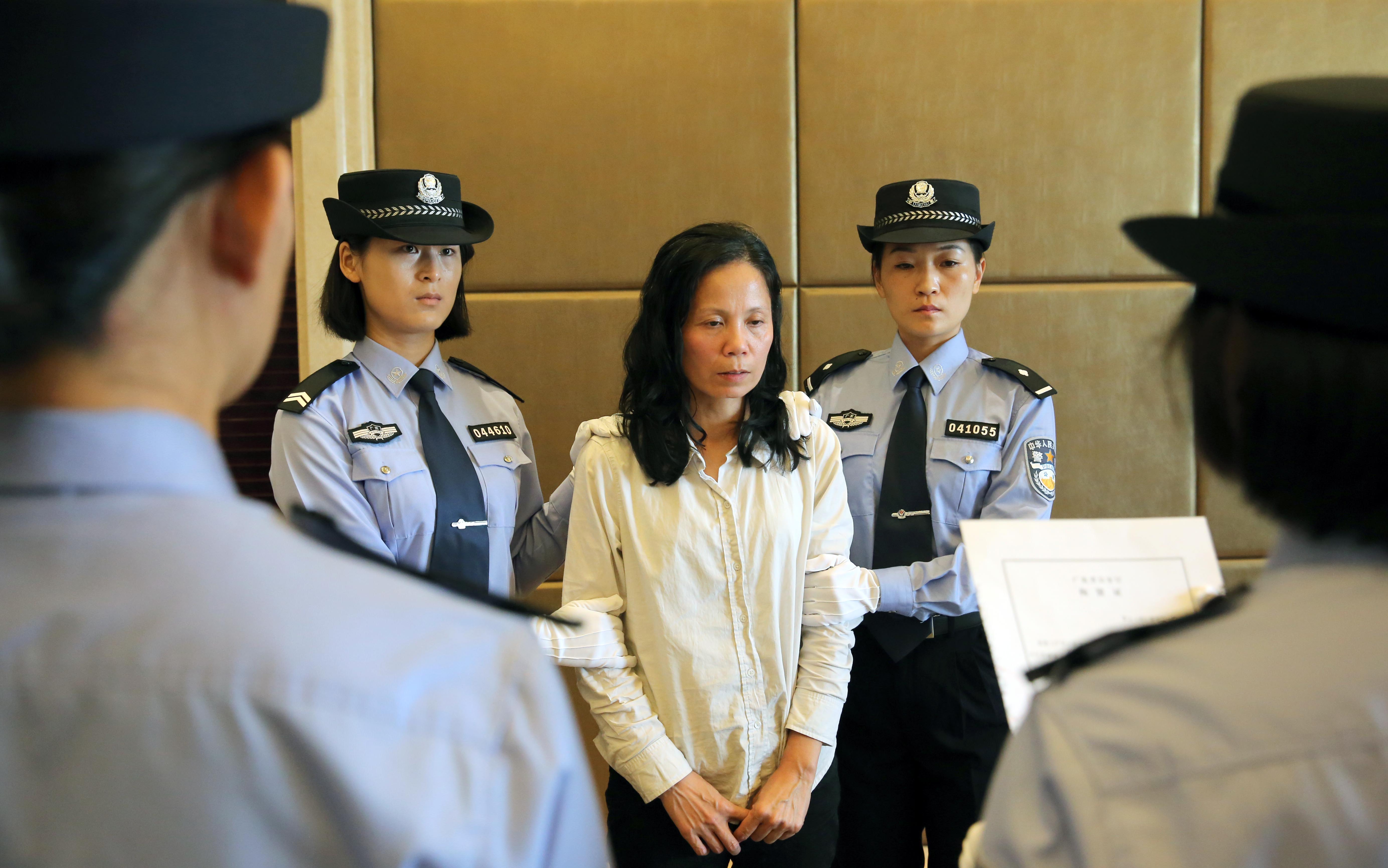 Corruption suspect Kuang Wanfang is detained after arriving at Changle Airport in Fuzhou, Fujian Province on Thursday. Photo: Xinhua 