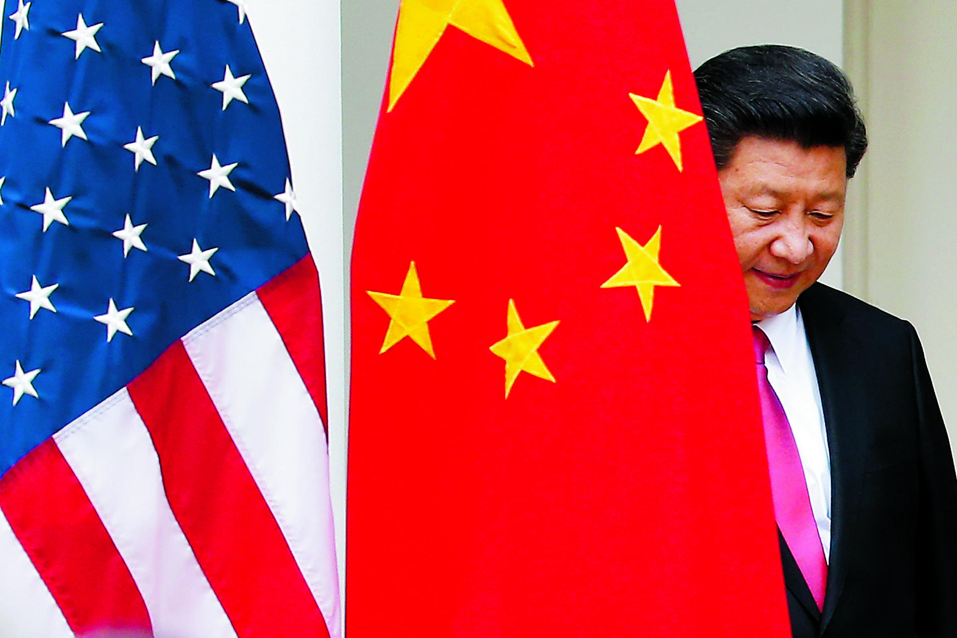 President Xi Jinping steps out from behind a Chinese flag as he takes his position for his joint news conference with President Barack Obama. Photo: AP