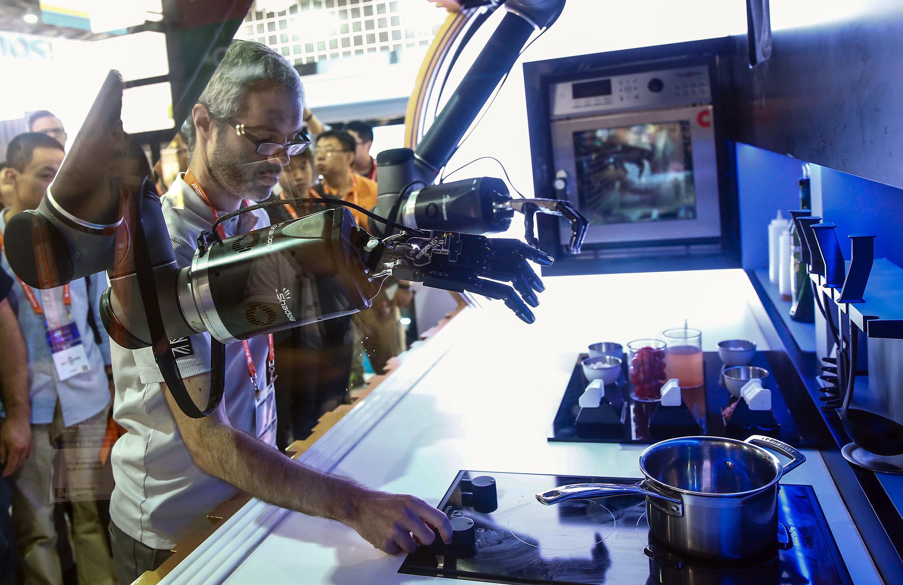An exhibitor demonstrates a robot to visitors during the first Consumer Electronics Show (CES) in Asia in Shanghai on May 25. China is focusing more on domestic consumption, high technology and innovation as it looks to wean itself off exports and state-led investment growth. Photo: AFP