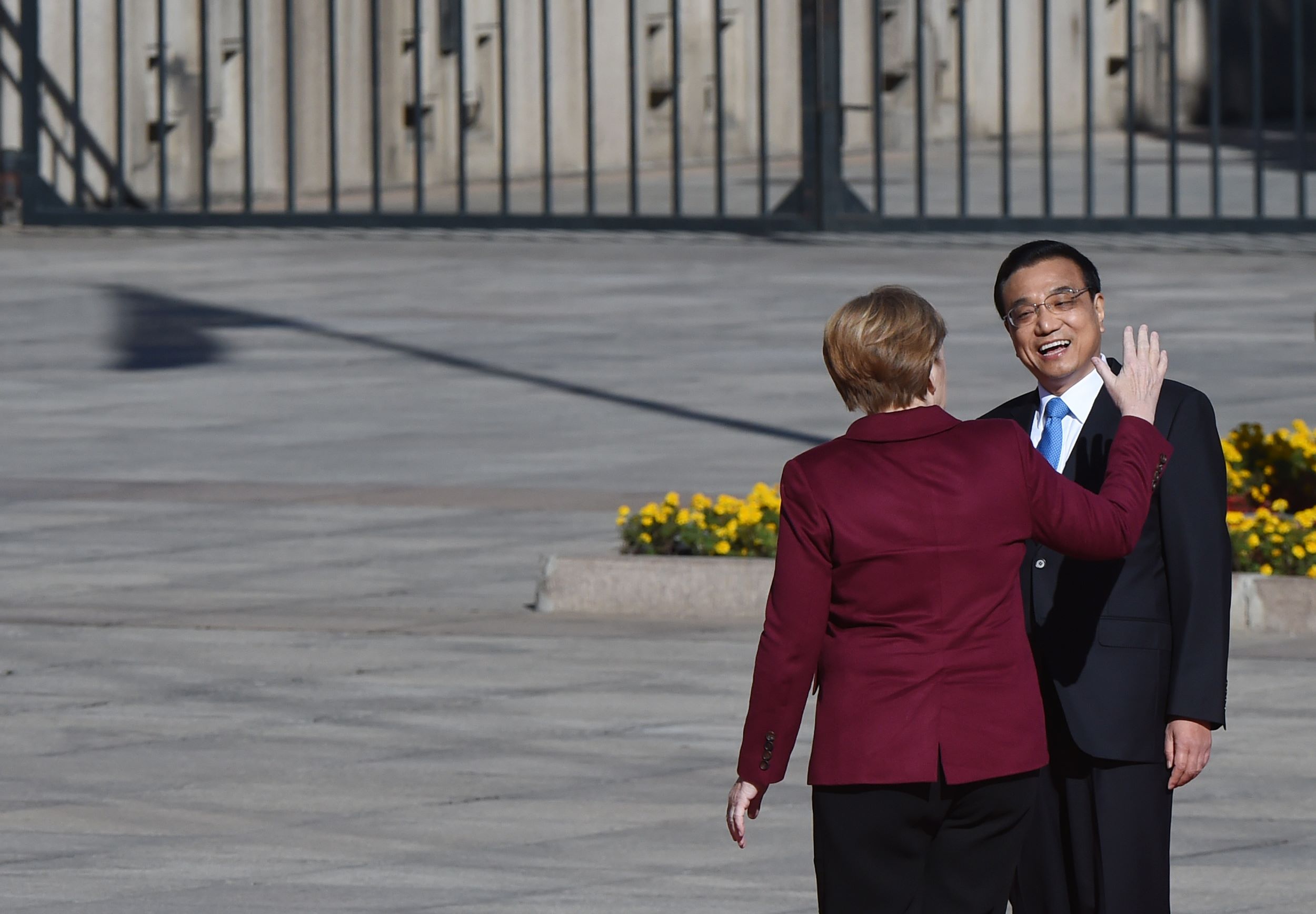 German Chancellor Angela Merkel chats with Chinese Premier Li Keqiang during a welcome ceremony outside the Great Hall of the People in Beijing on Thursday. Photo: AFP