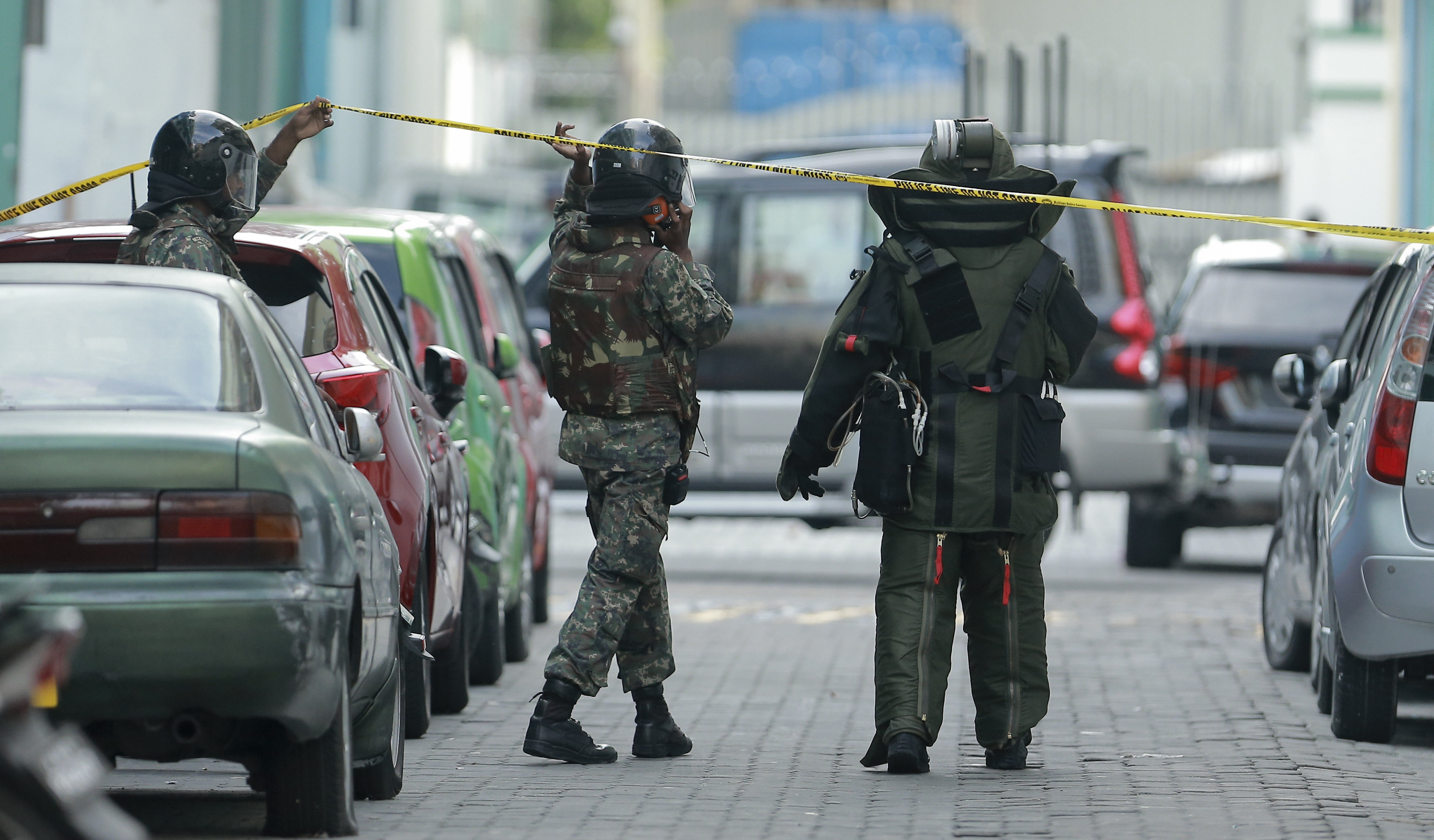 Police and Maldives National Defence Force personnel cordon off an area suspecting an explosive inside the engine compartment of a parked broken car in Male, Maldives on Wednesday. It was later confirmed to be a hoax. Photo: AP 