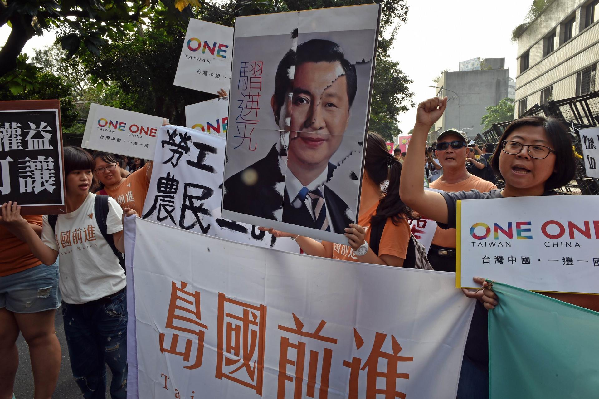 Taiwanese protesters chant slogans as they hold up banners and posters in Taipei yesterday. Photo: AFP