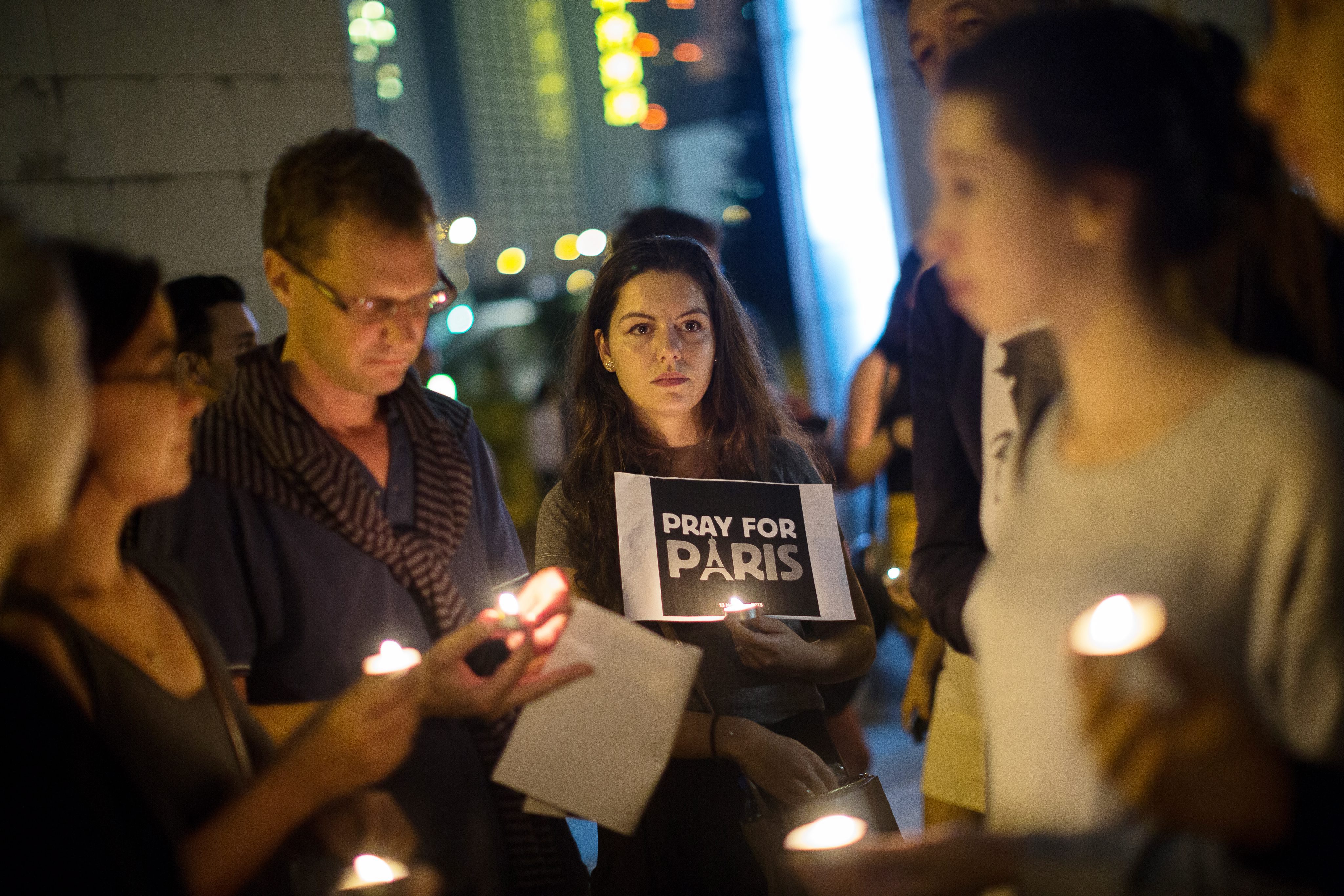 Mourners in Hong Kong hold candles during a vigil held for the victims of the 13 November Paris attacks. Photo: EPA