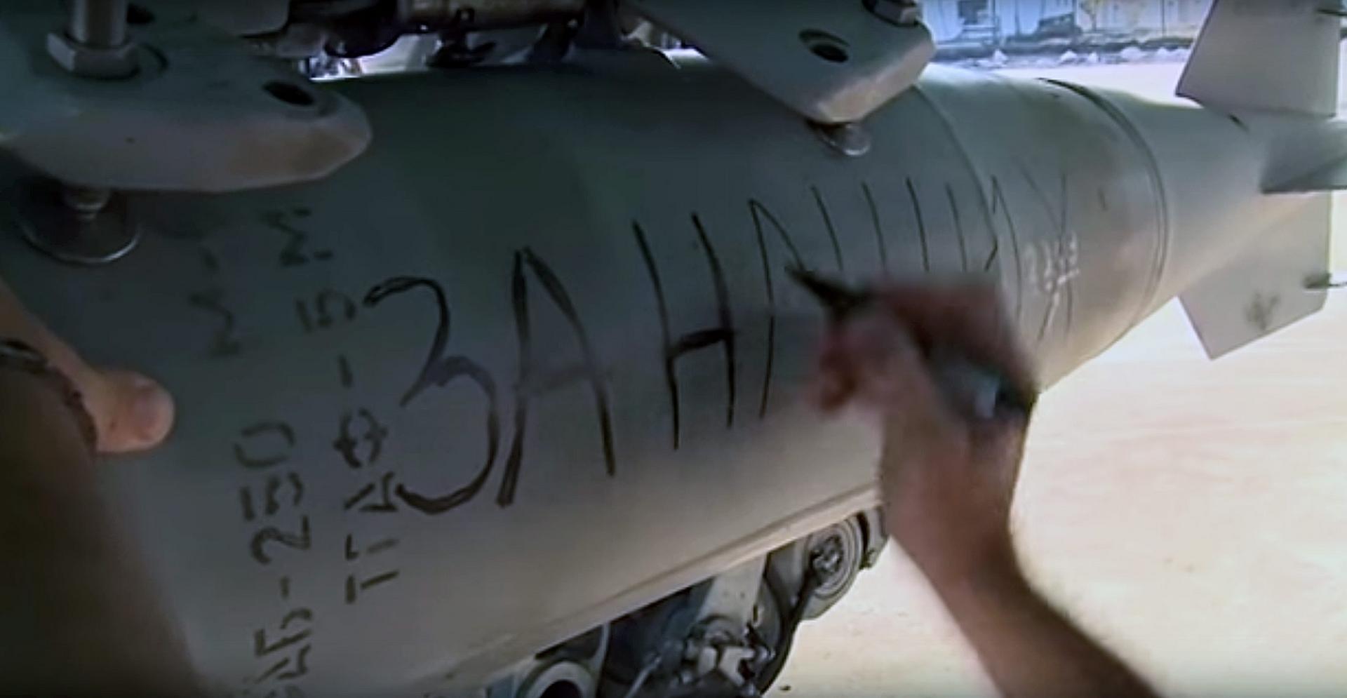 The words 'For our people' written on a bomb on a Russian warplane as it prepares for a raid at an airbase in Syria.Photo: EPA