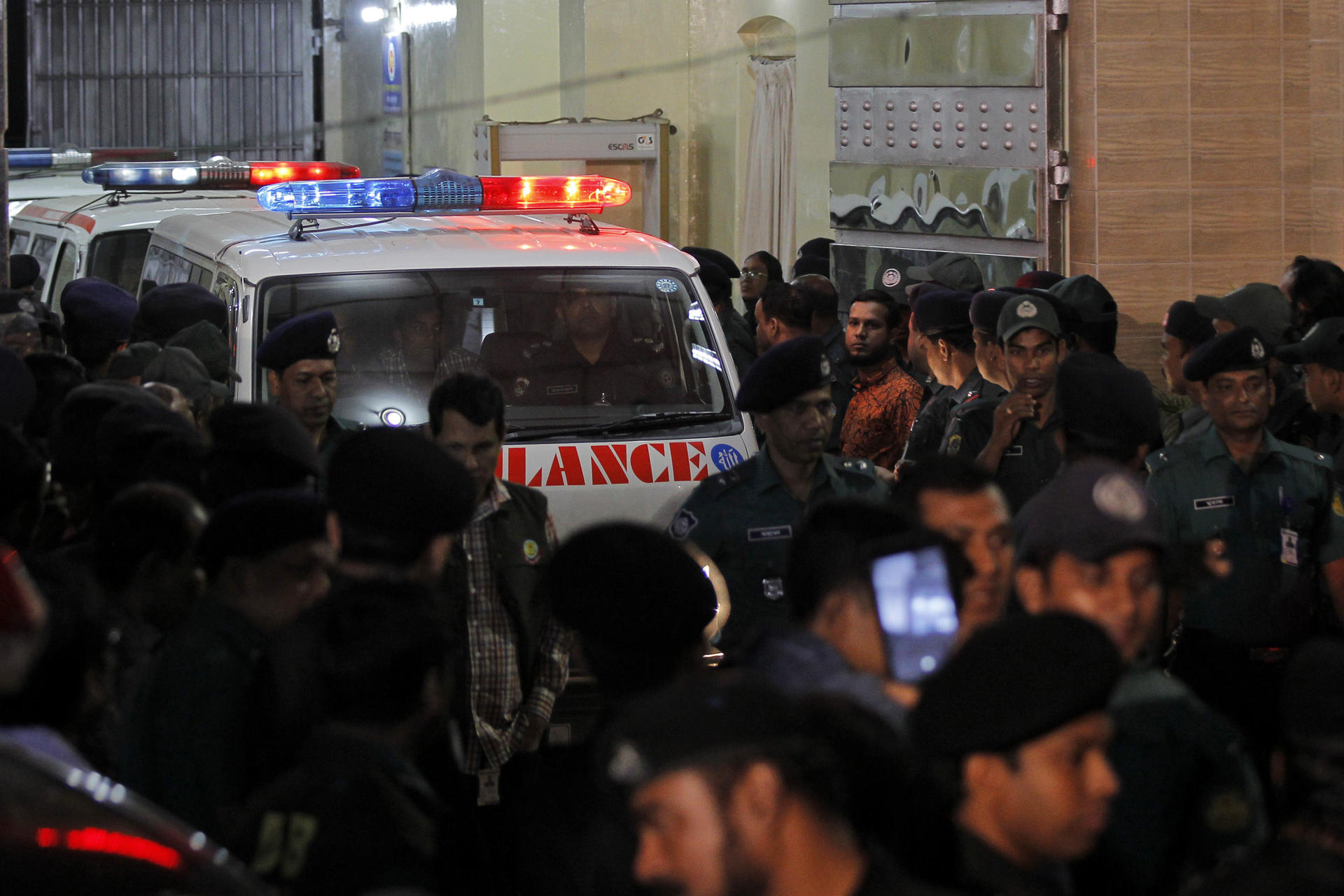 Ambulances carrying the dead bodies leave the Central Jail. Photo: AP